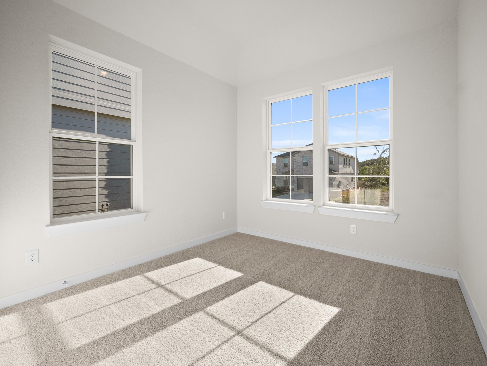 bedroom with carpet, windows & a sloped ceiling