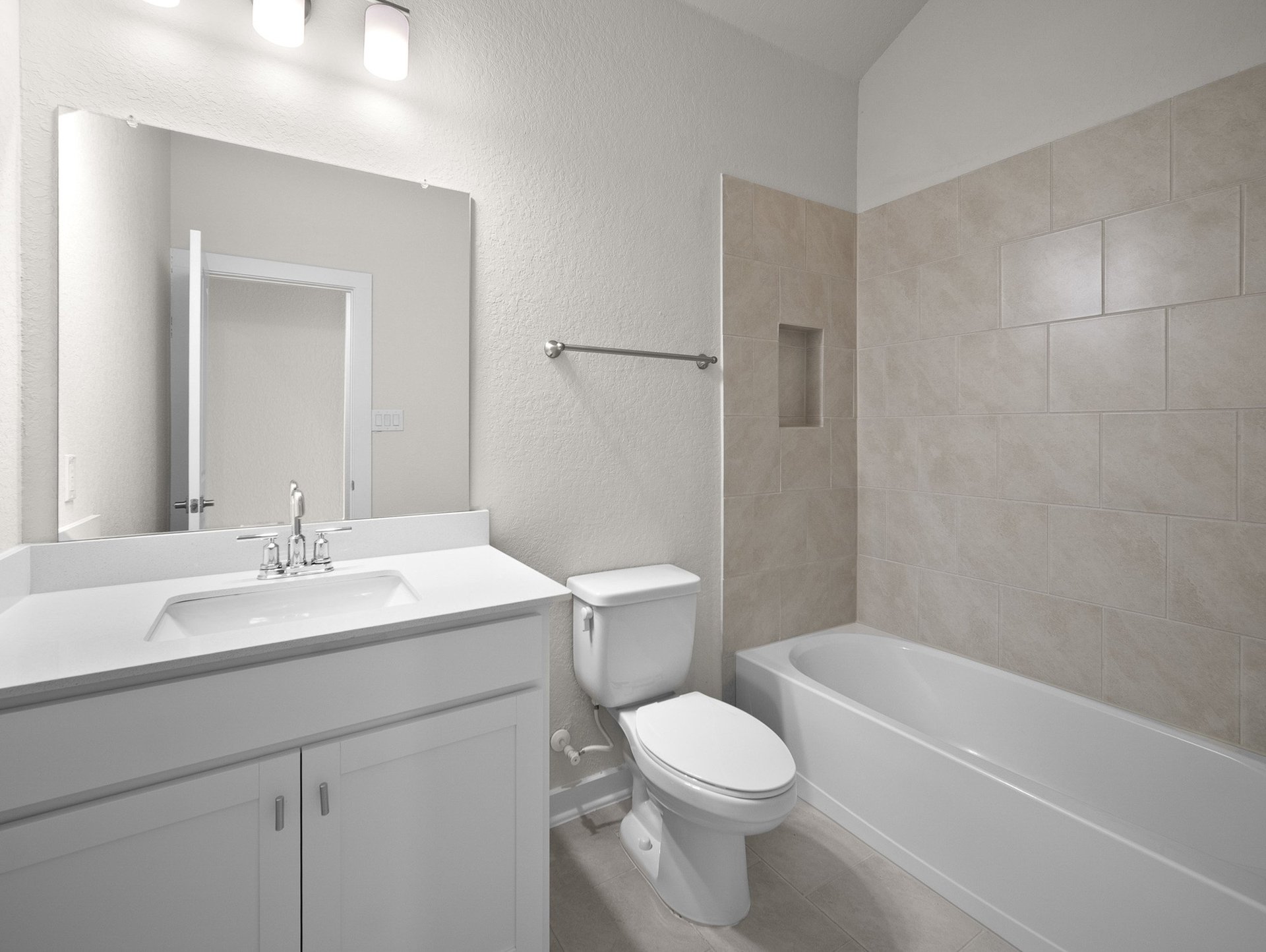 secondary bathroom with soaking tub, quartz countertops & a sink