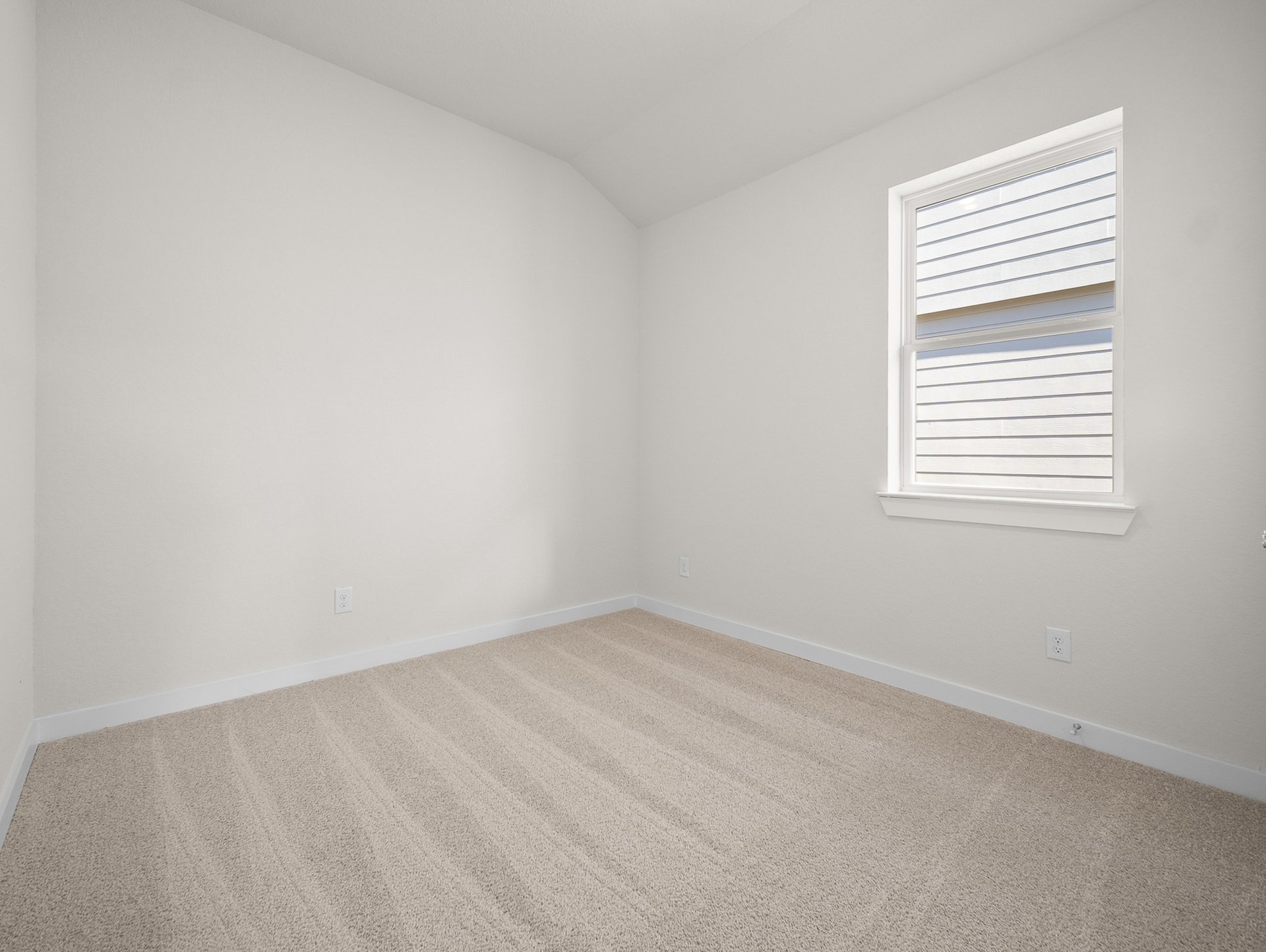 bedroom with carpet, window & a sloped ceiling