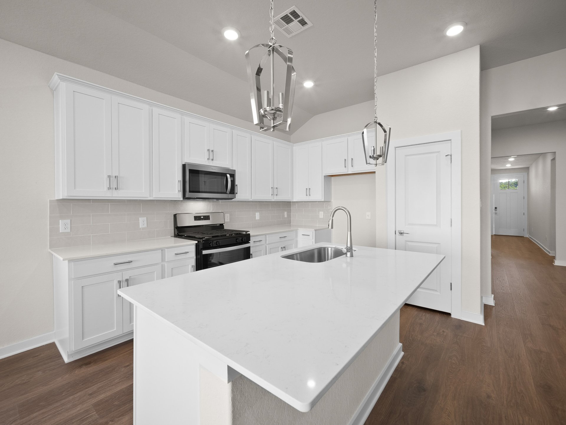 kitchen with quartz countertops, pendant lighting & white cabinets