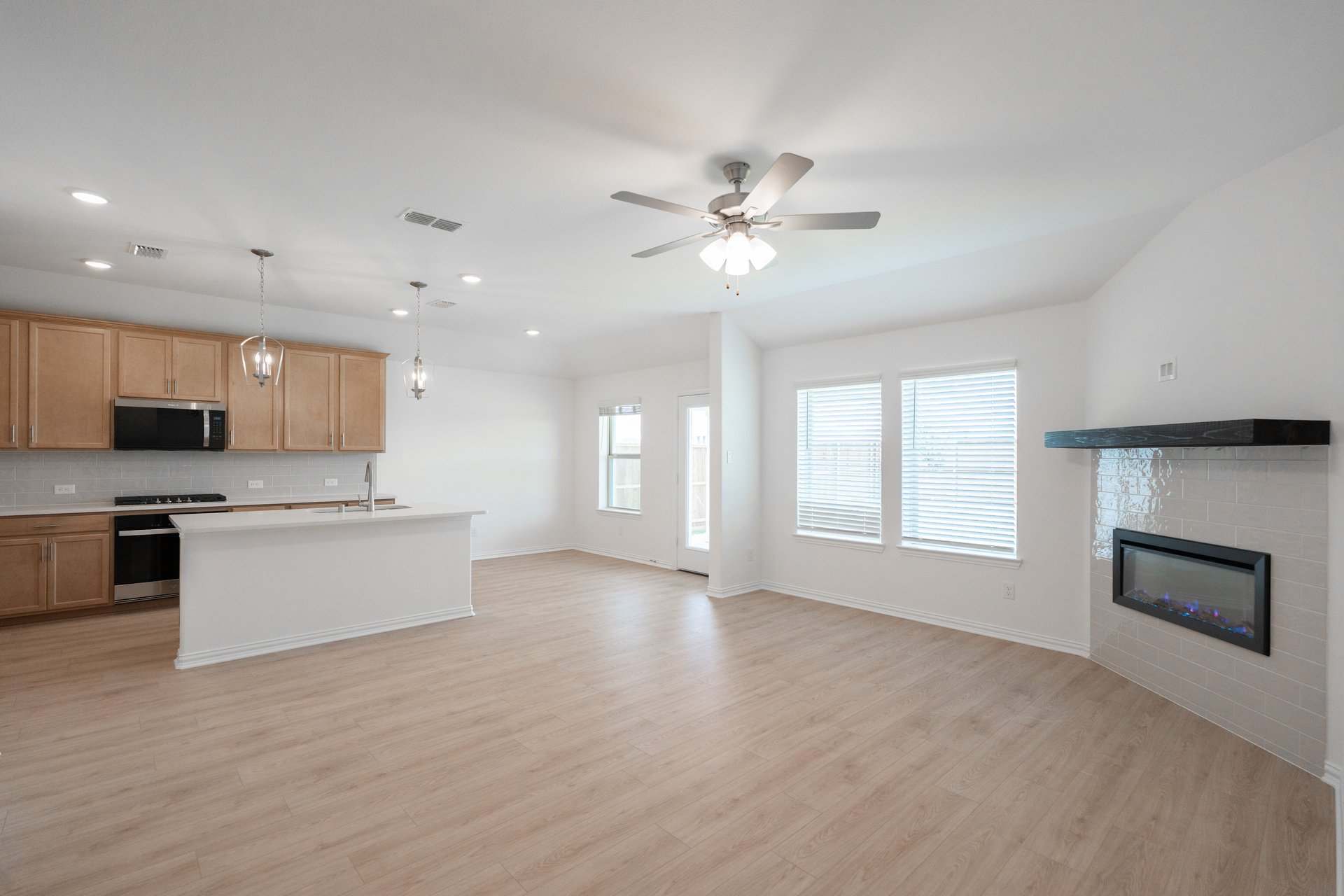 open great room with wood floors and fireplace