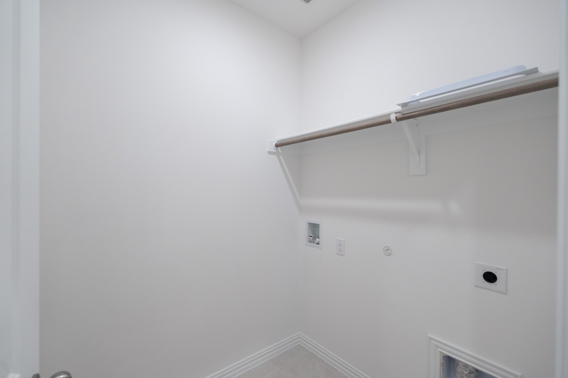 laundry room with tile floors and white shelf