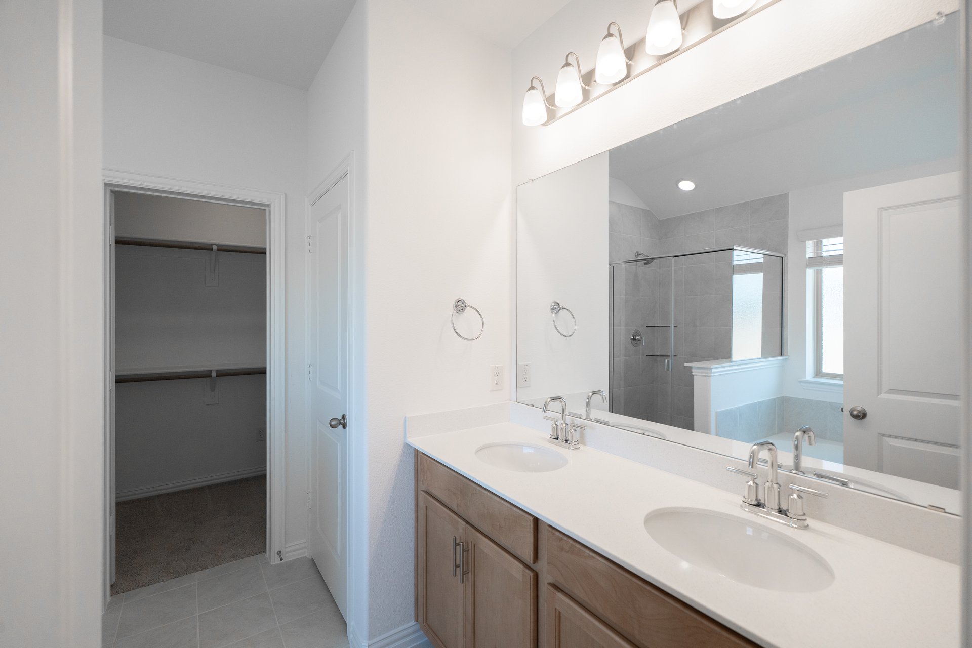 primary bathroom with two sinks and tile floors