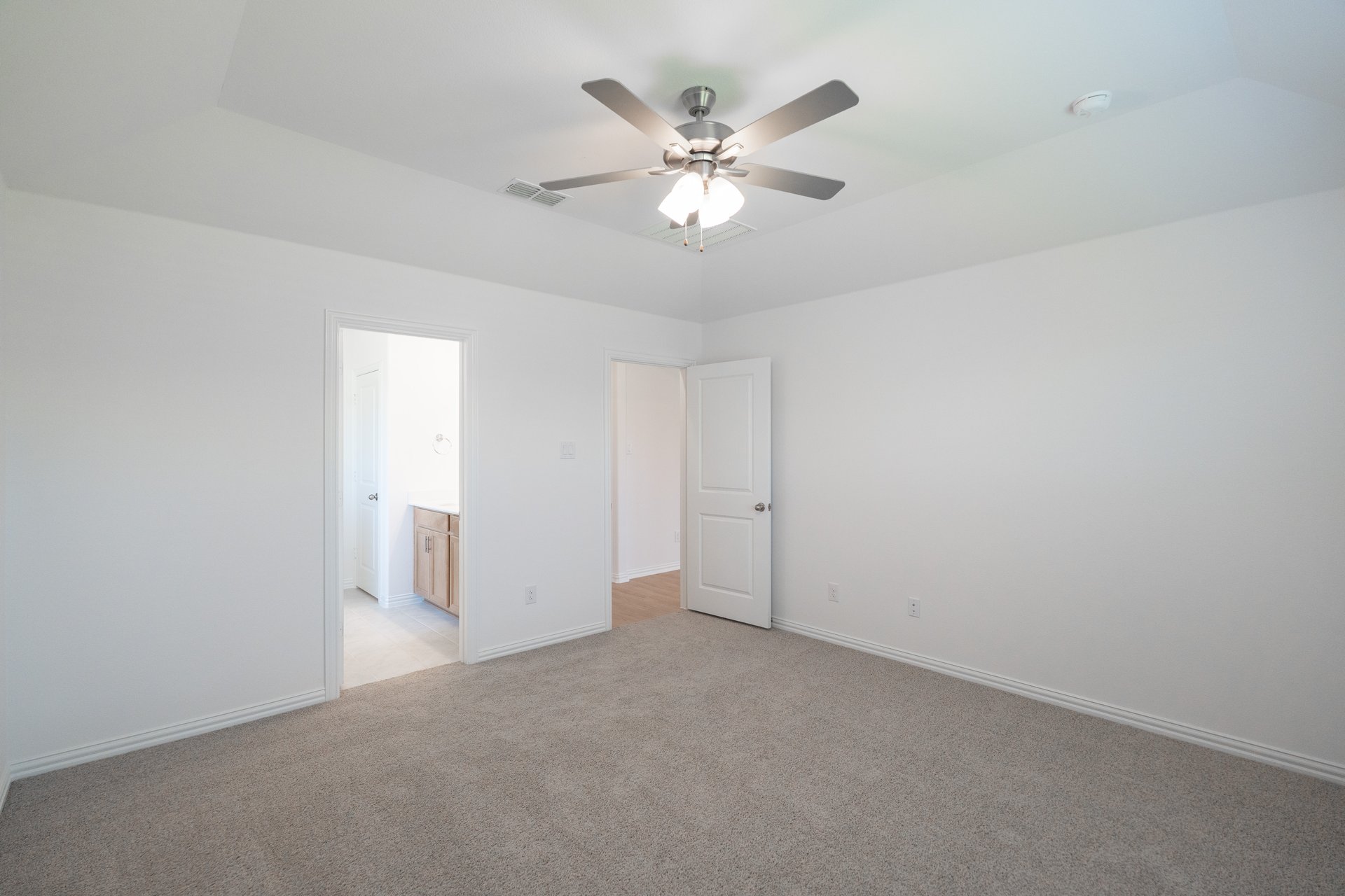 primary bedroom with carpet and ceiling fan