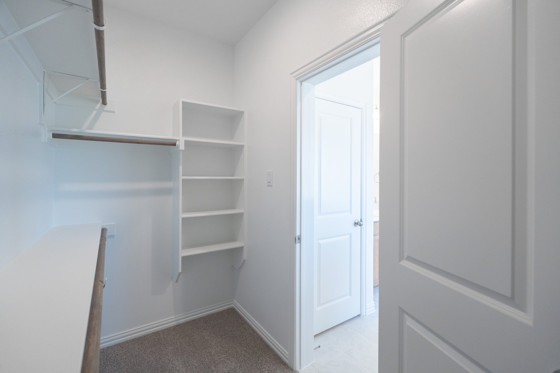 primary bedroom closet with carpet and white shelves