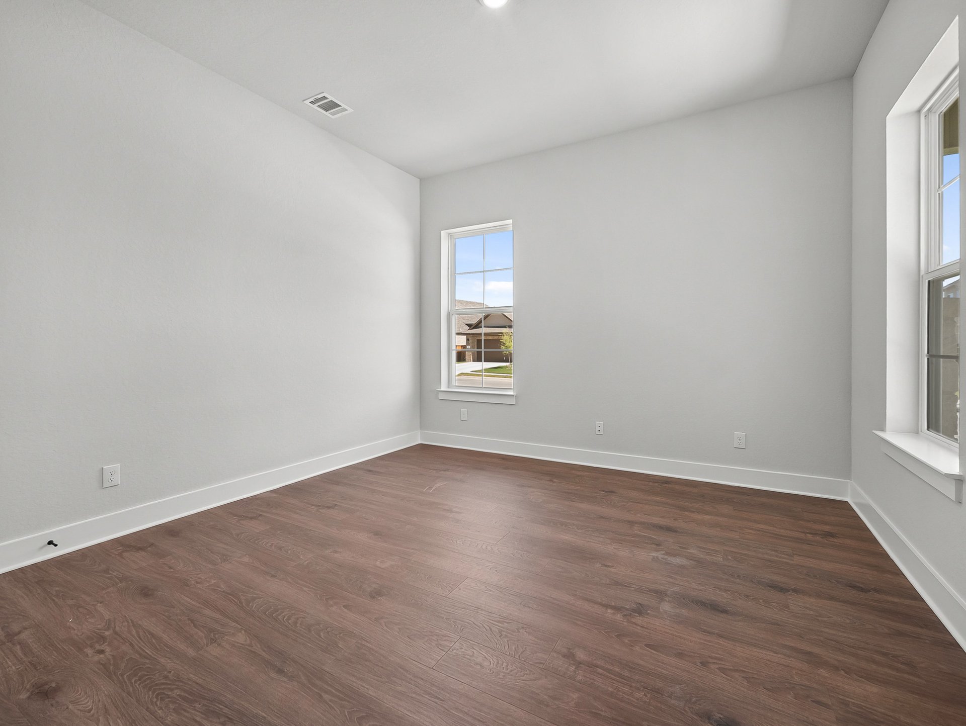 study with brown flooring, windows & recessed lighting