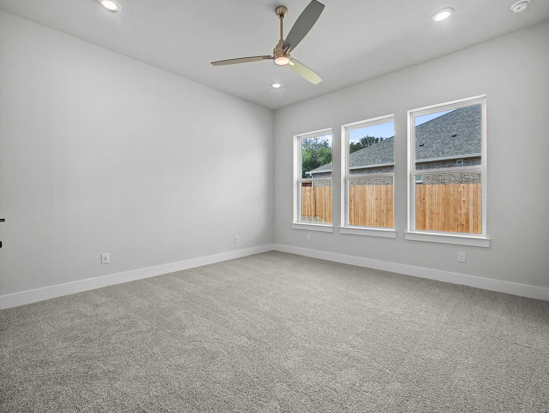 bedroom with carpet, windows & a ceiling fan