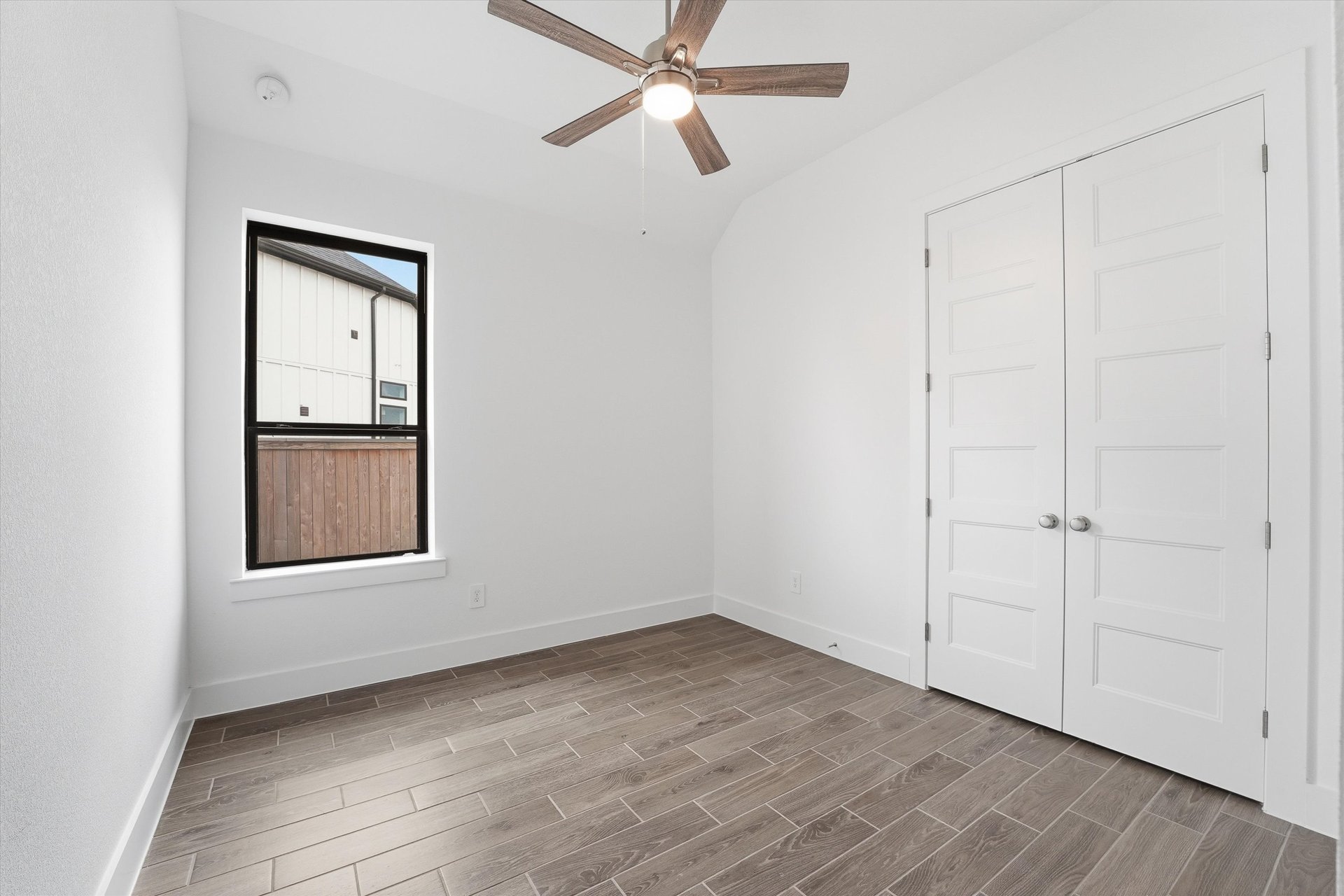 guest bedroom with hardwood flooring