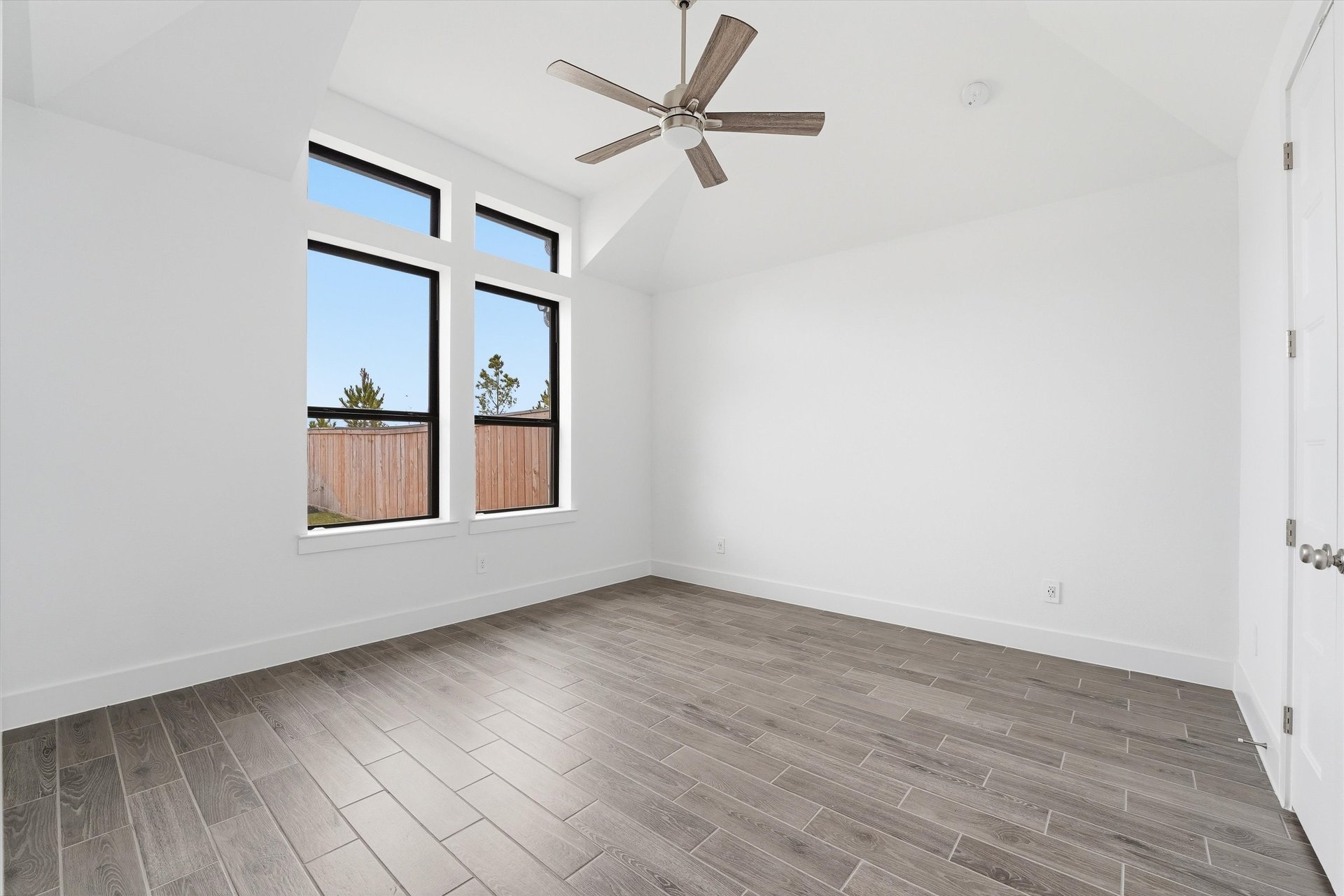 primary bedroom with hardwood flooring and ceiling fan
