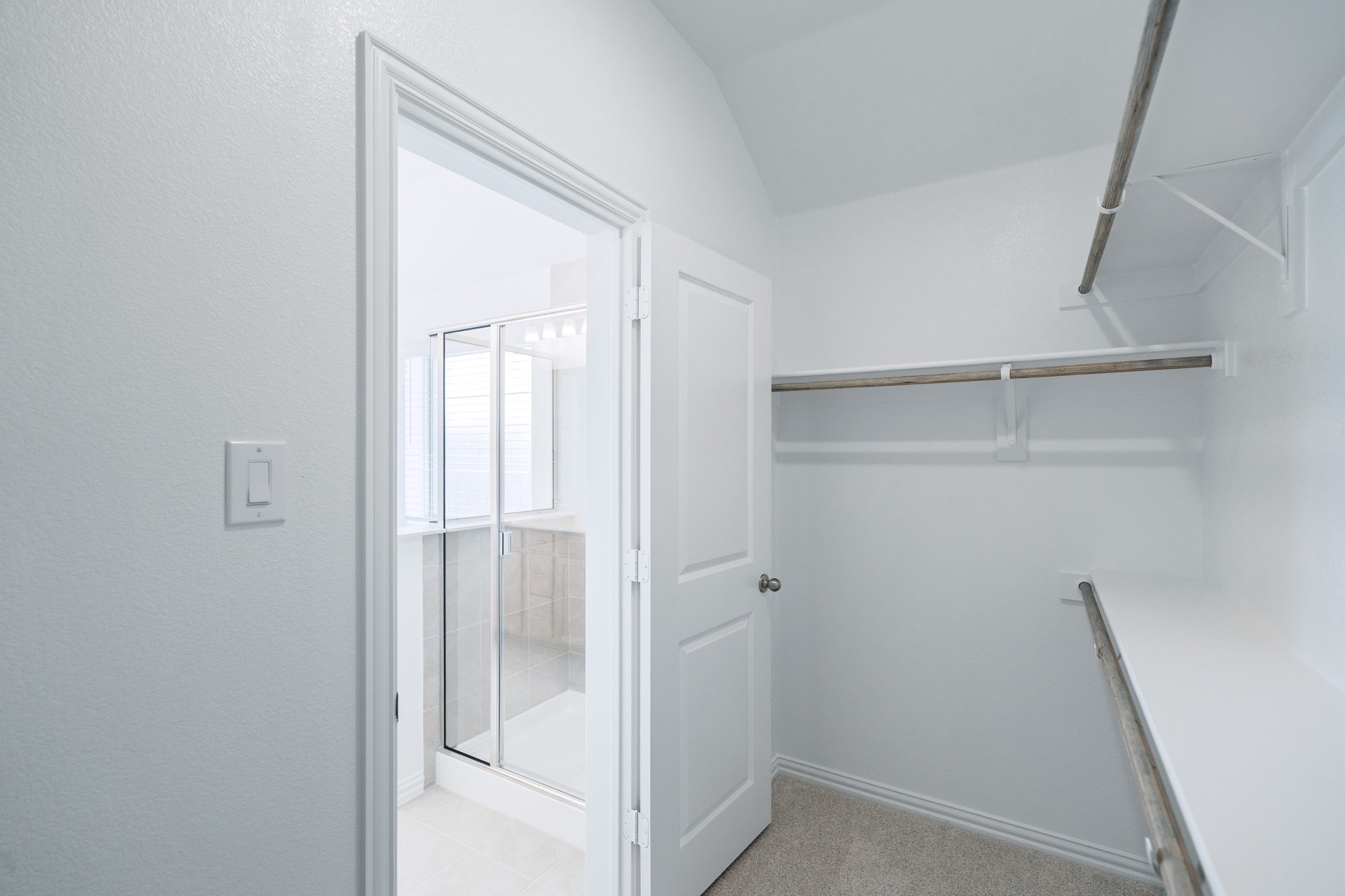 primary closet with carpet and white shelves