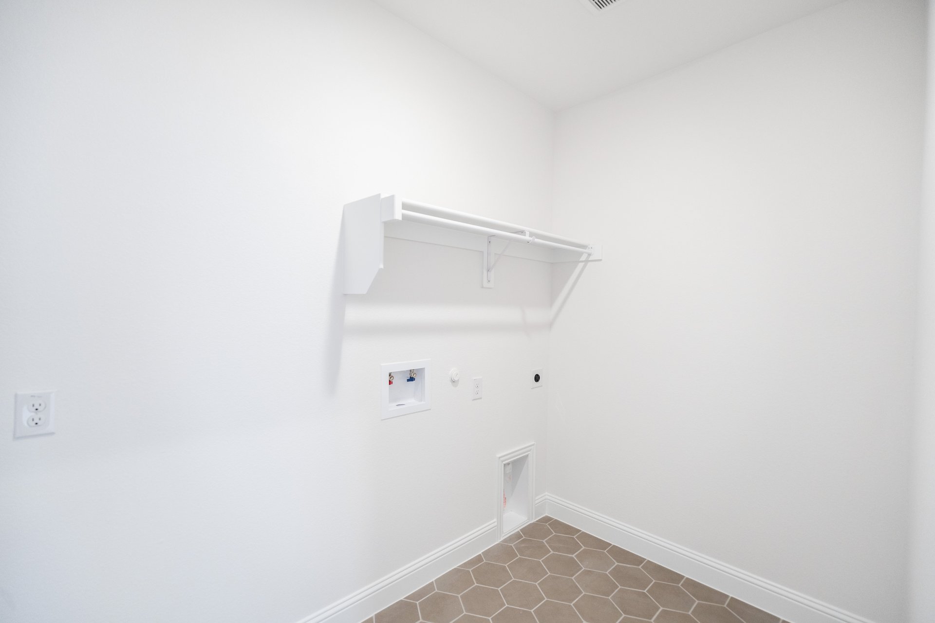 laundy room with a shelf and tile flooring
