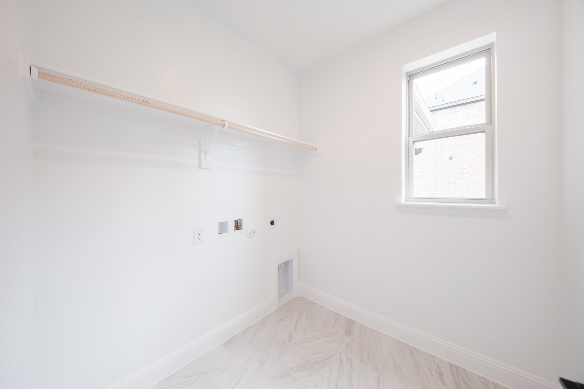 laundry room with tile floors and white shelf