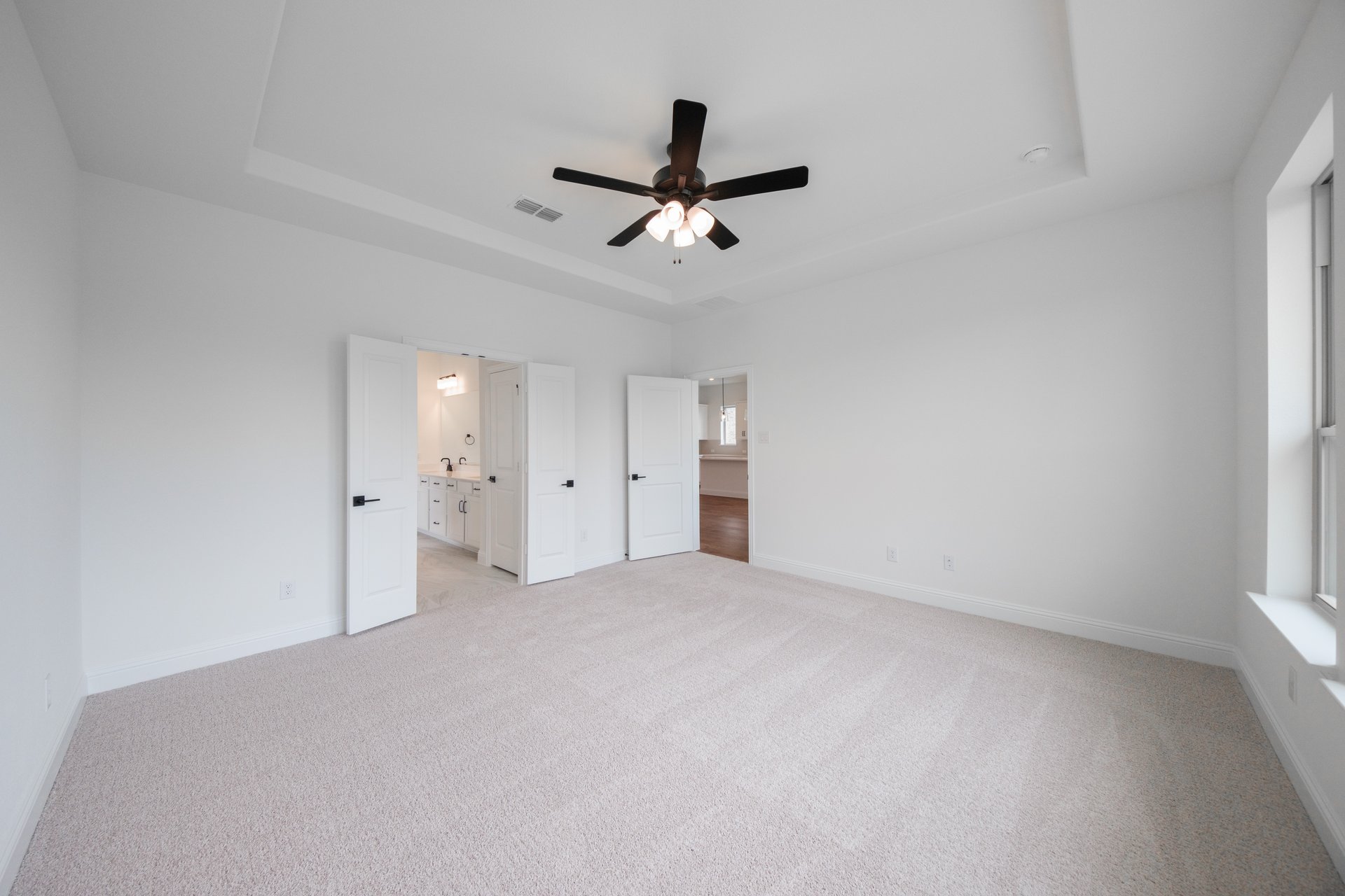 primary bedroom with carpet and ceiling fan
