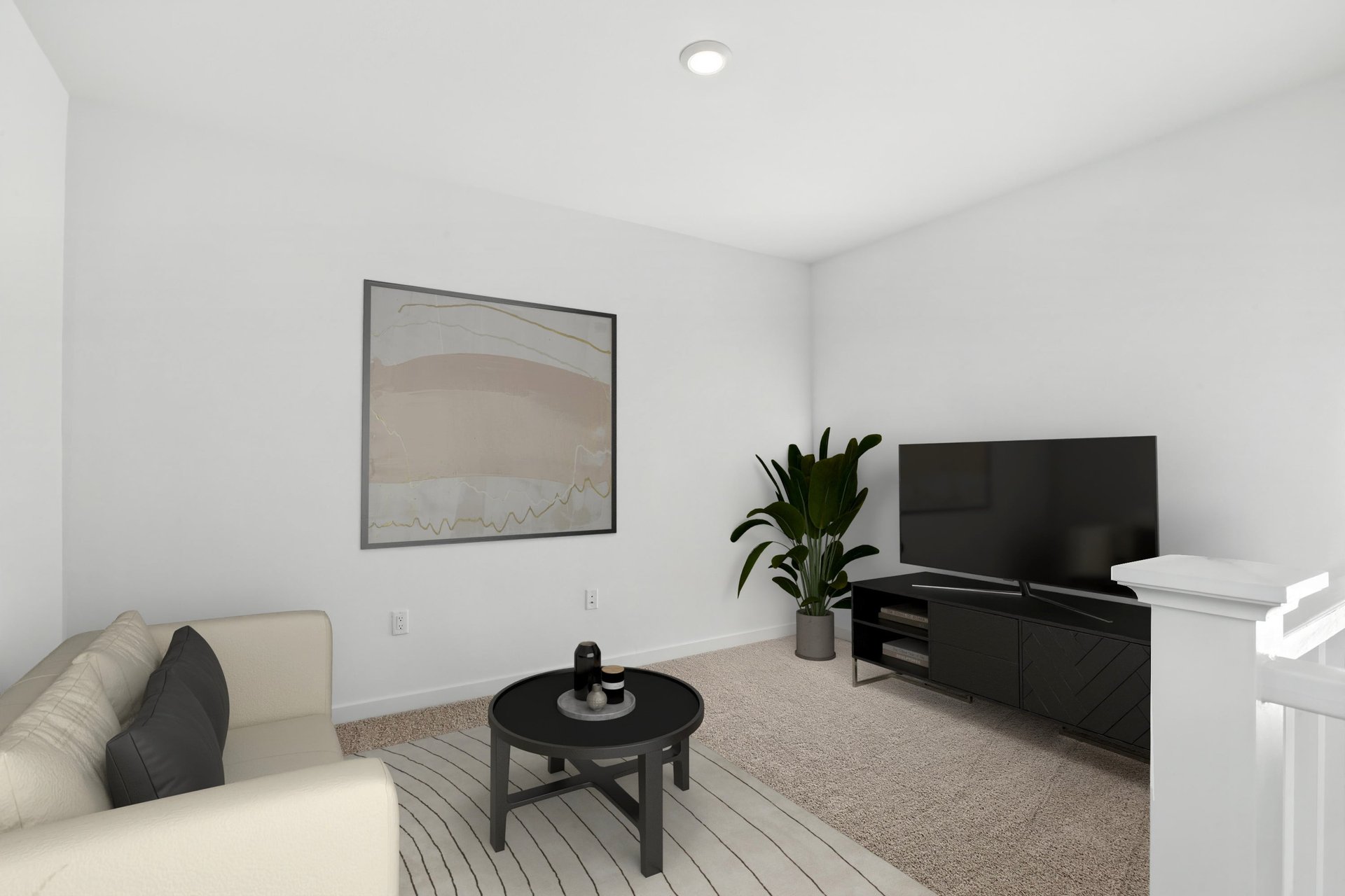 loft with tan carpet, sofa with two black pillows, round black coffee table, modern wall art, and television