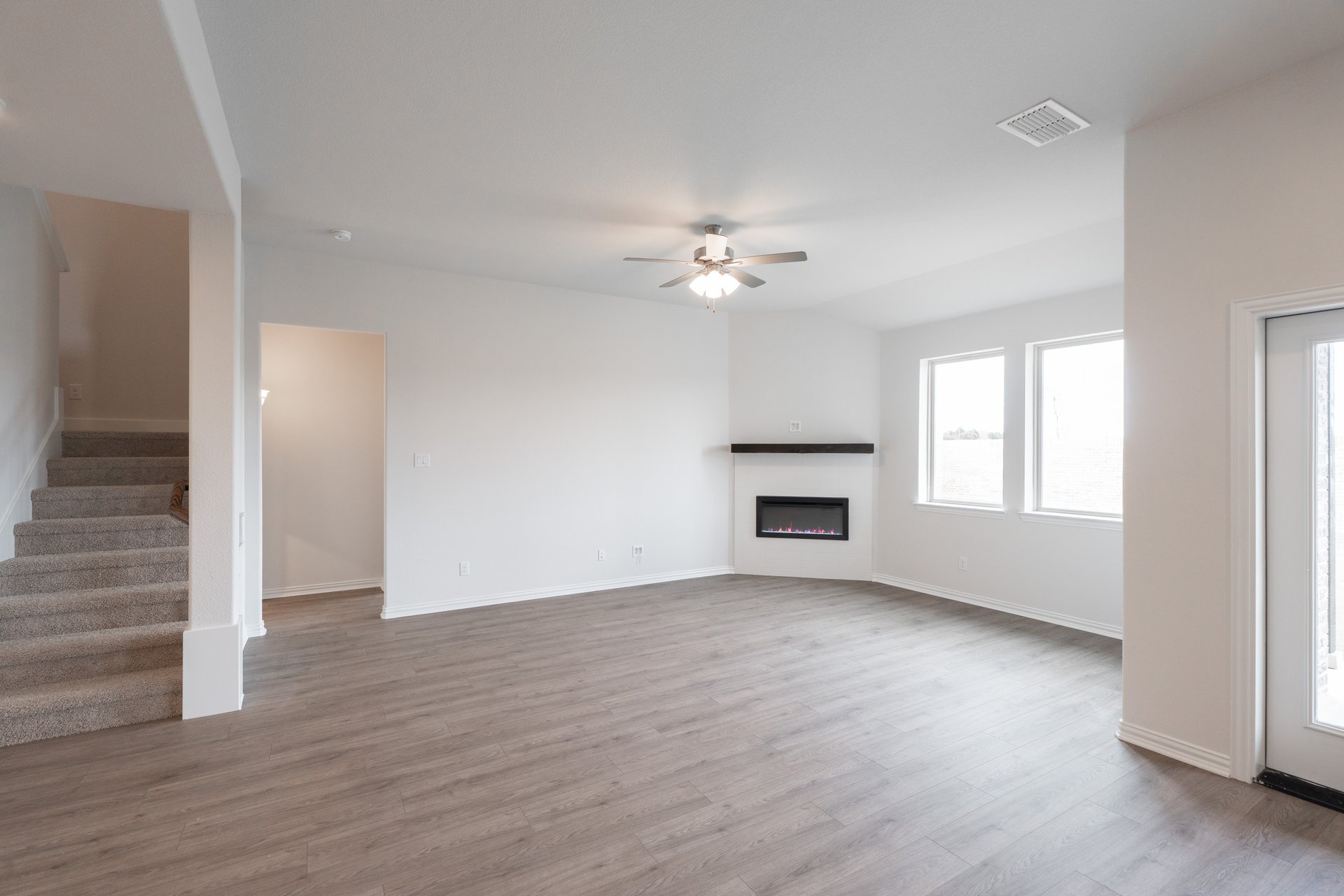 open great room with wood floors and fireplace