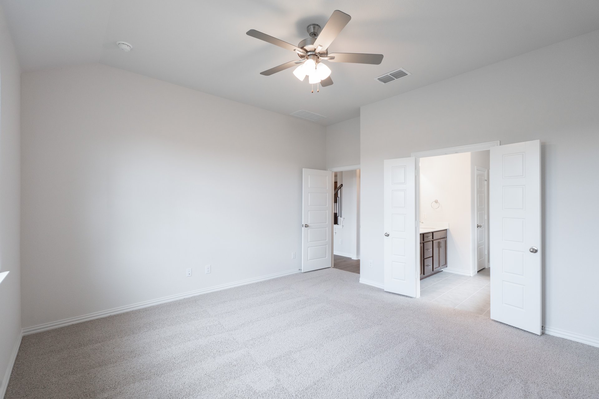 primary bedroom with carpet and ceiling fan