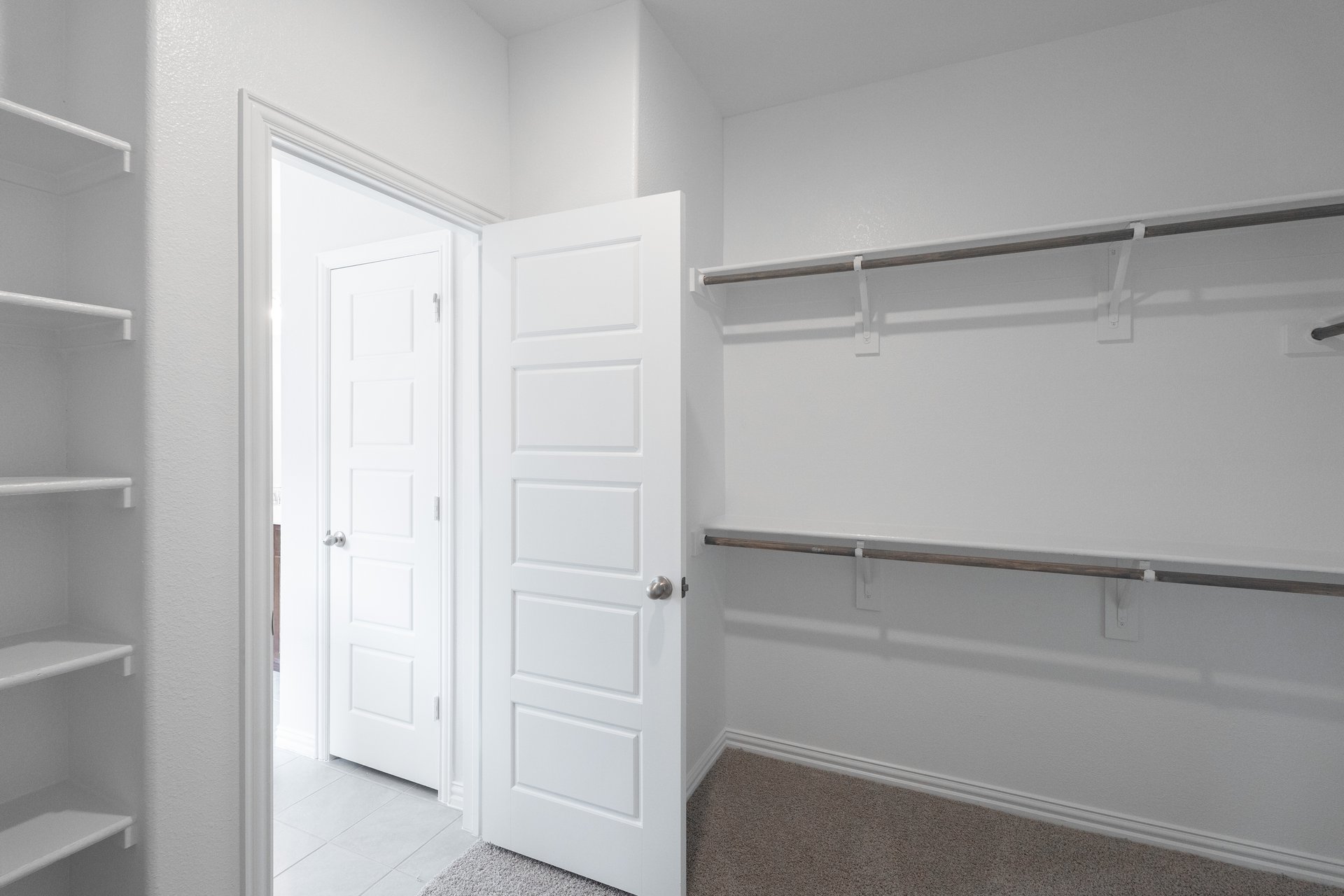 primary bedroom closet with carpet and white shelves