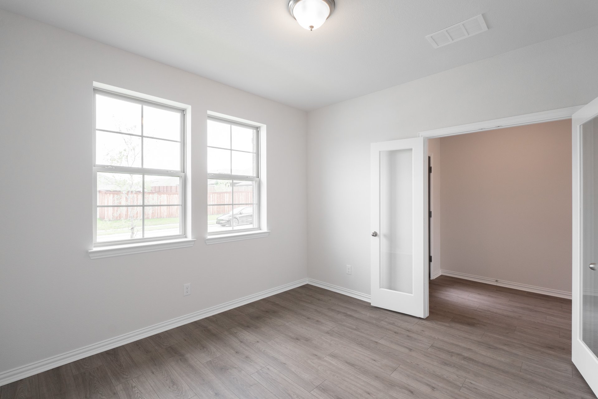 private study with wood floors and windows