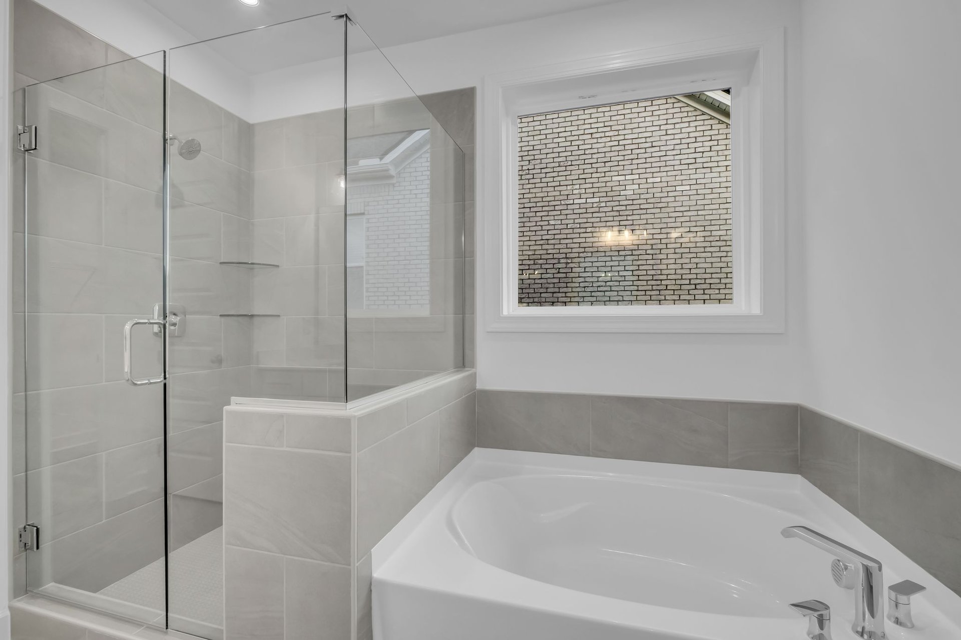 primary bathroom with glass walk-in shower and soaking tub