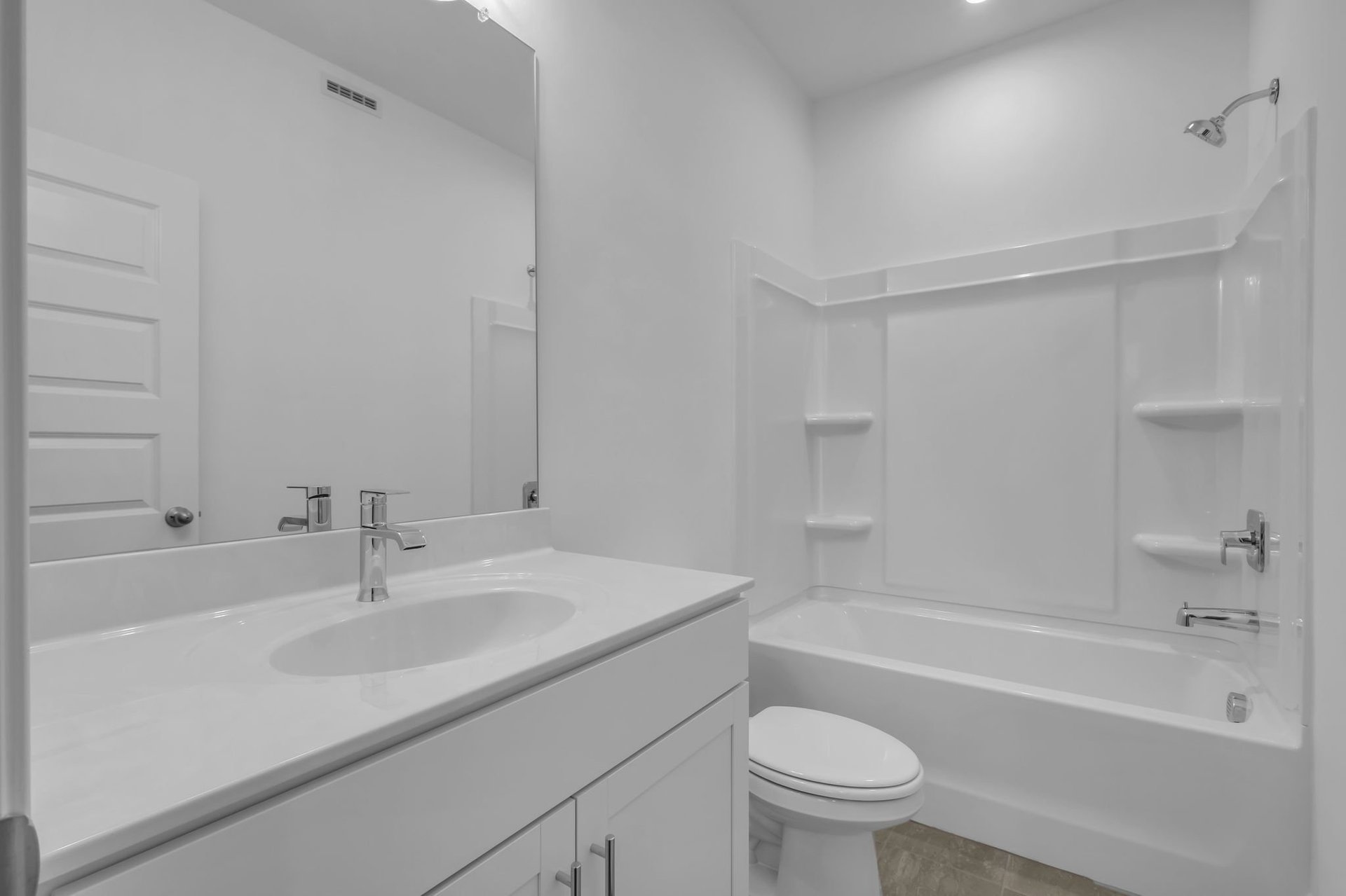 secondary bathroom with white cabinets and a shower and tub combination