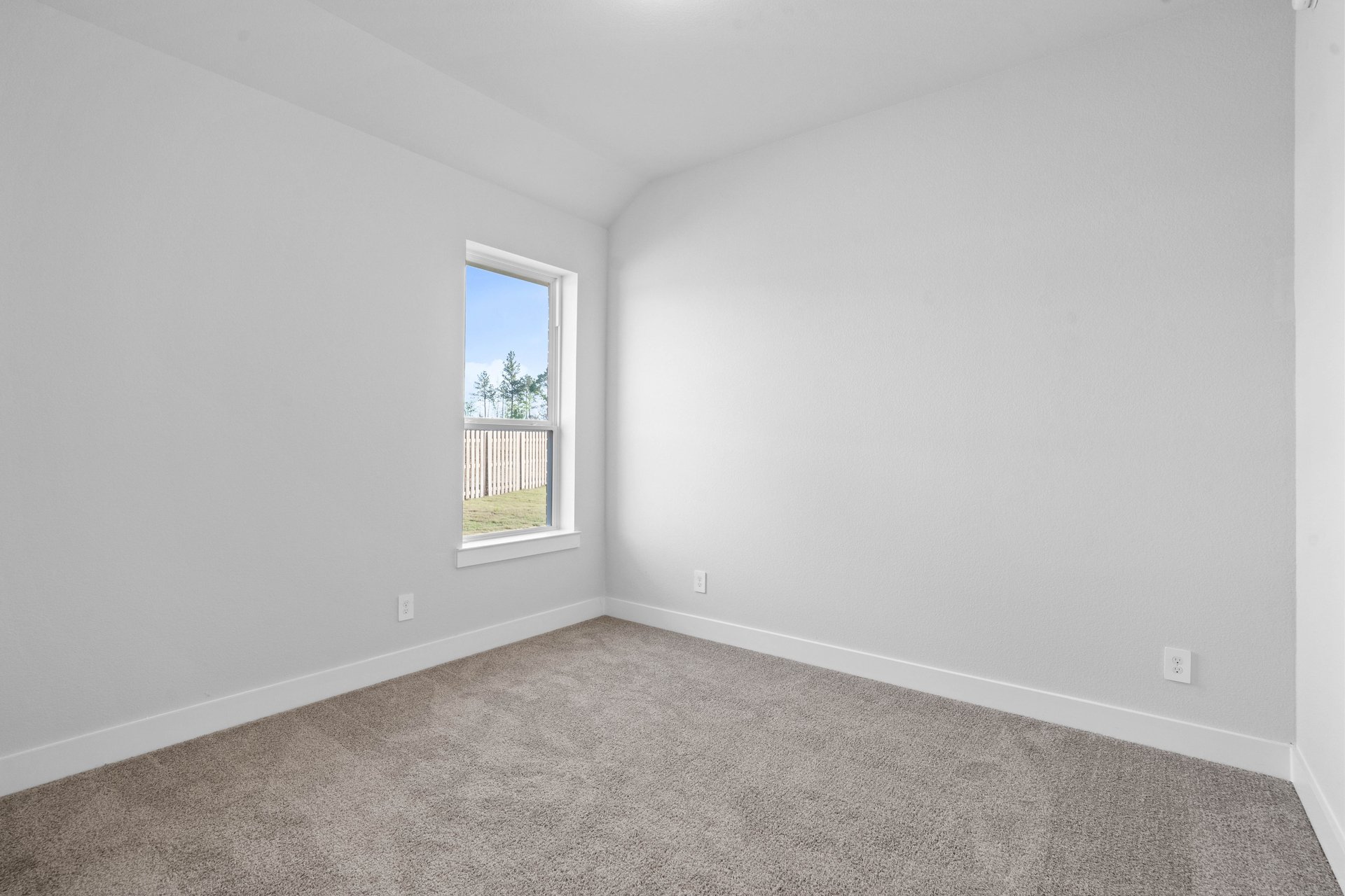 guest bedroom with carpet and window