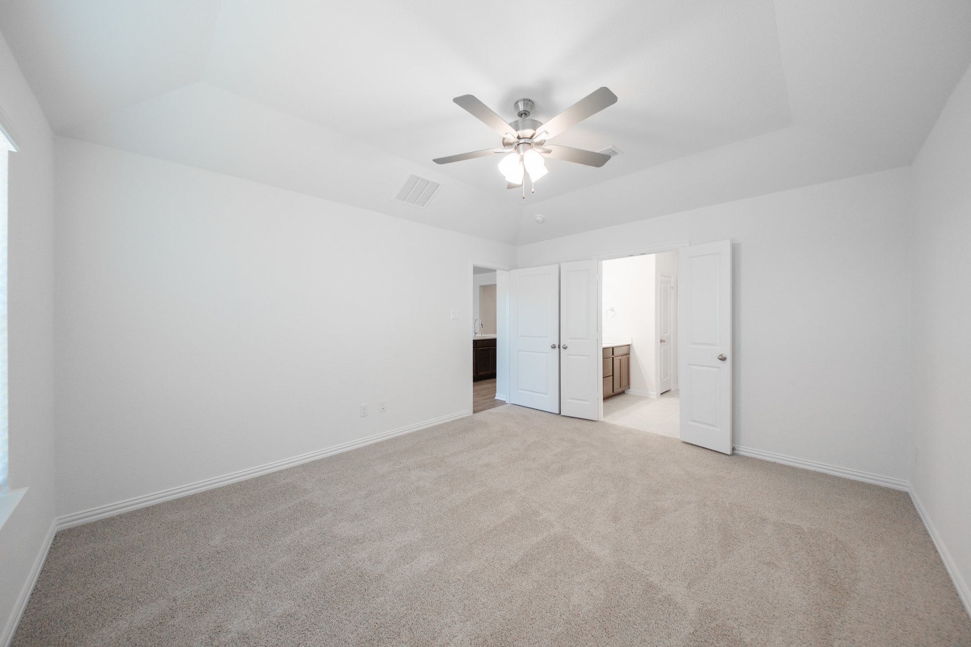 primary bedroom with carpet and ceiling fan