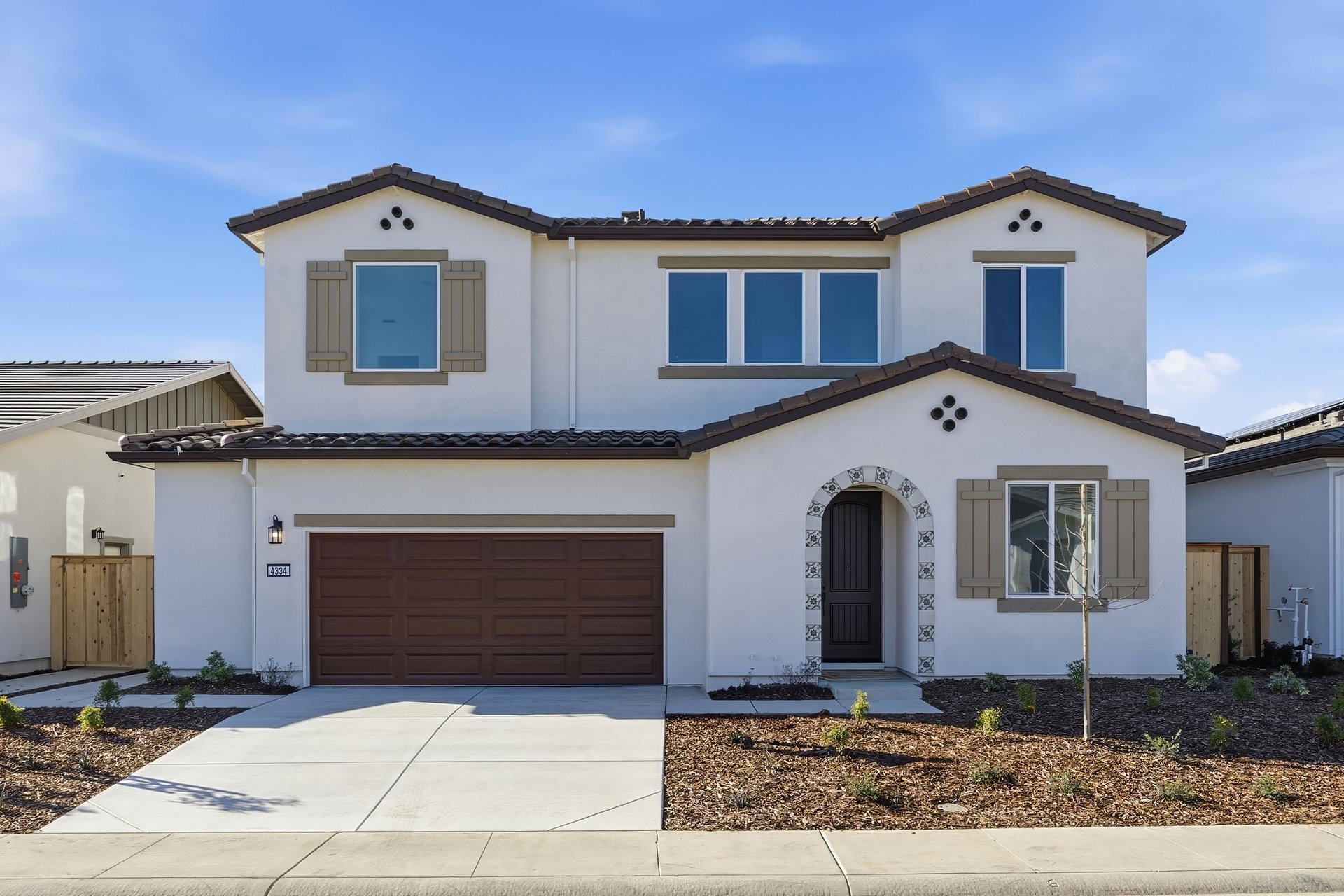 front exterior of two-story white and brown spanish style home