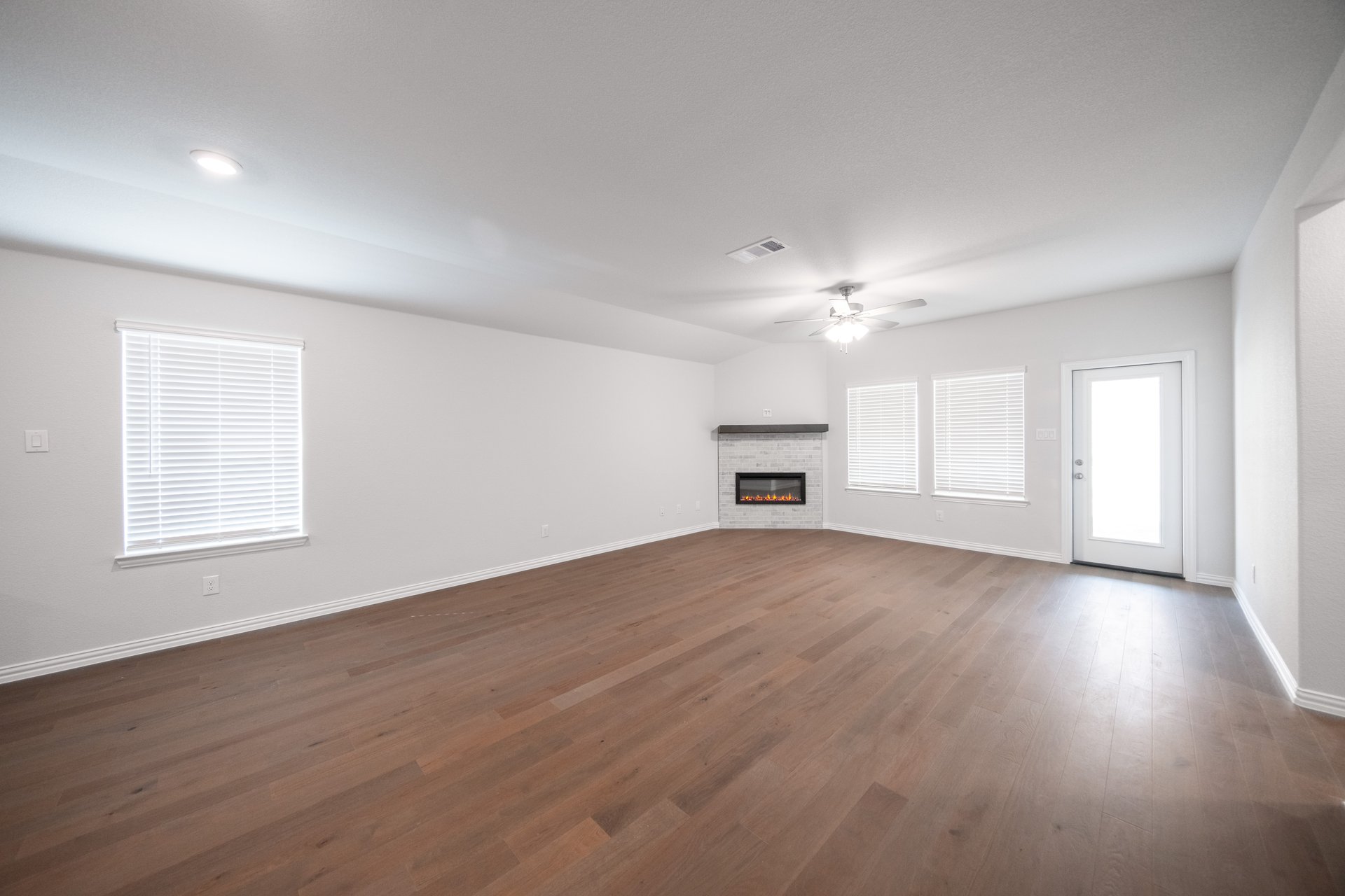 open great room with wood floors and fireplace
