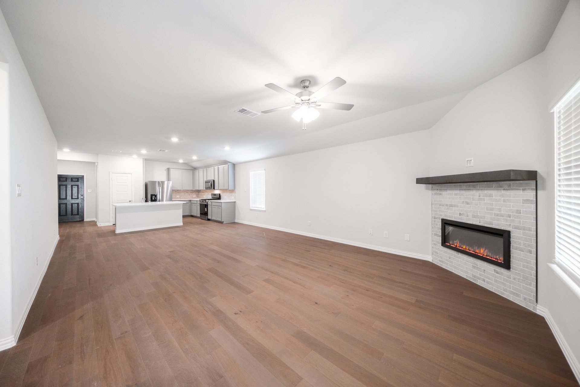 open great room with wood floors and fireplace