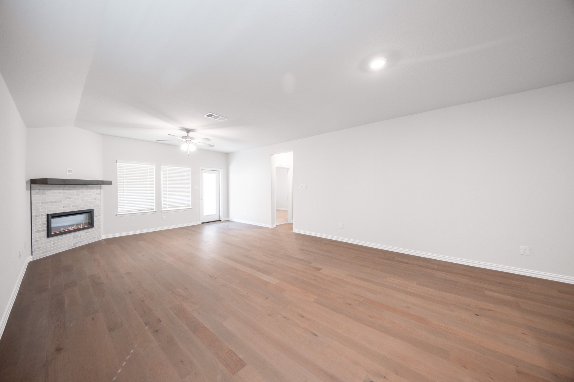 open great room with wood floors and fireplace