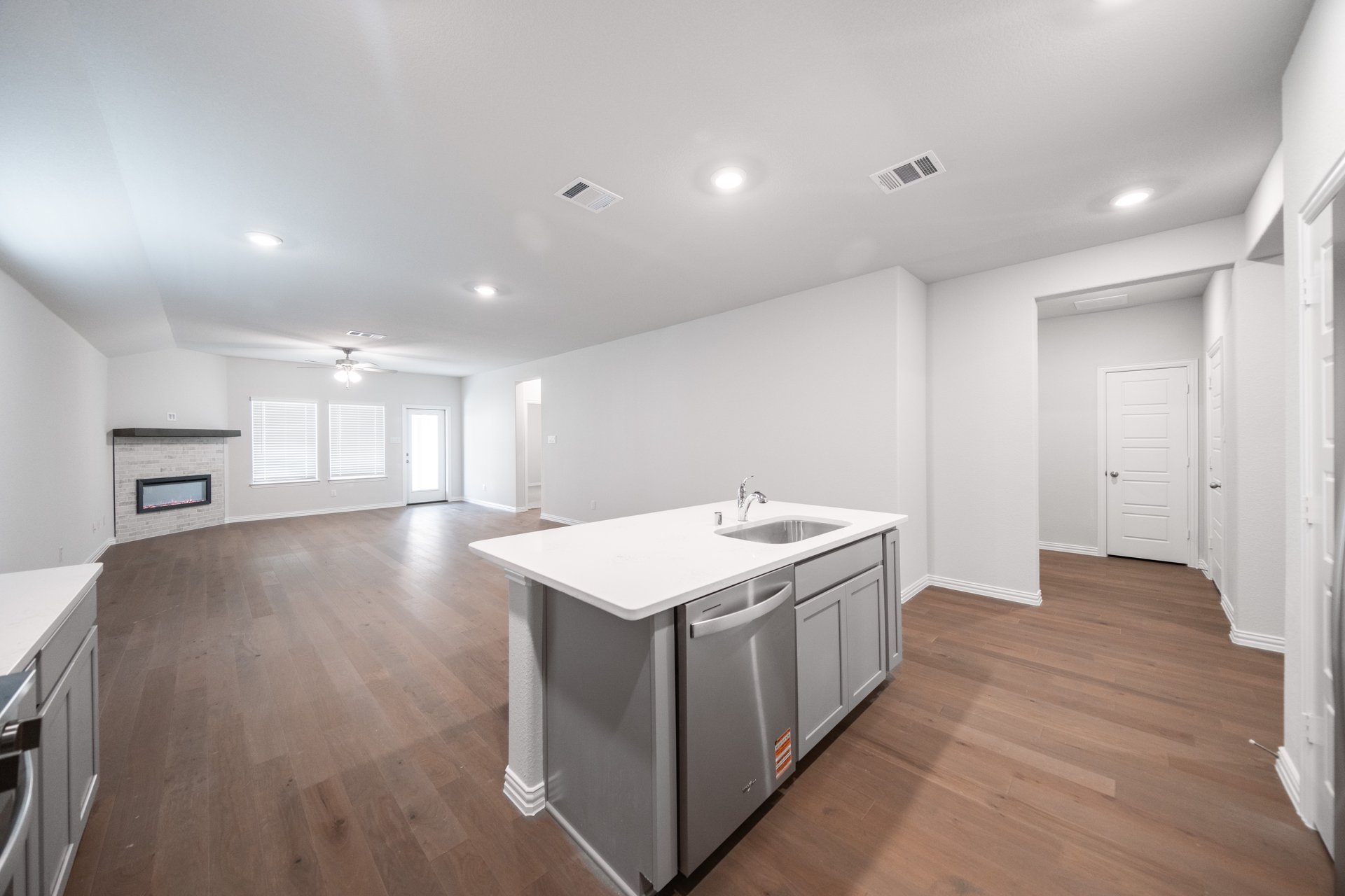 open kitchen with wood floors and white cabinets