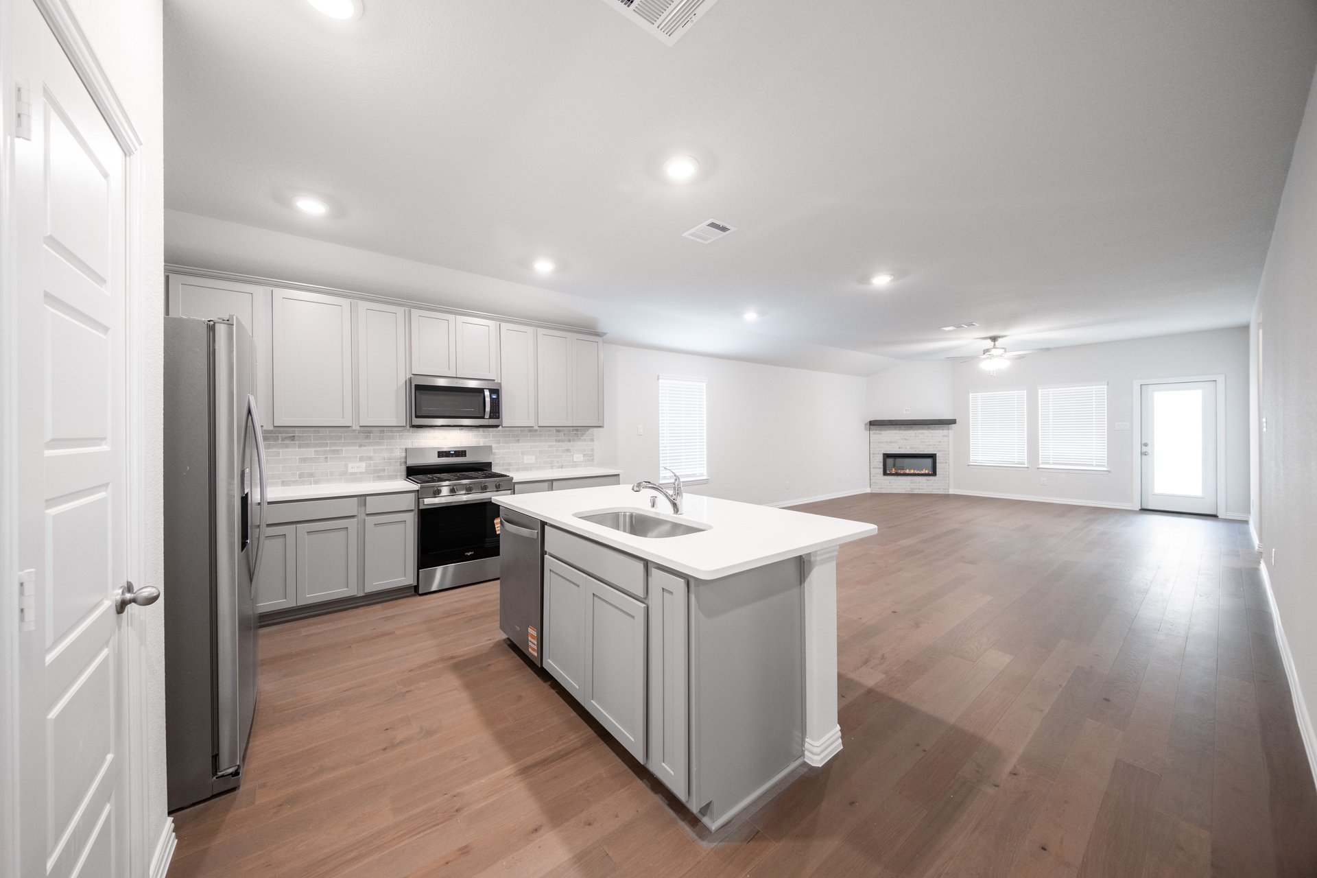 open kitchen with wood floors and white cabinets