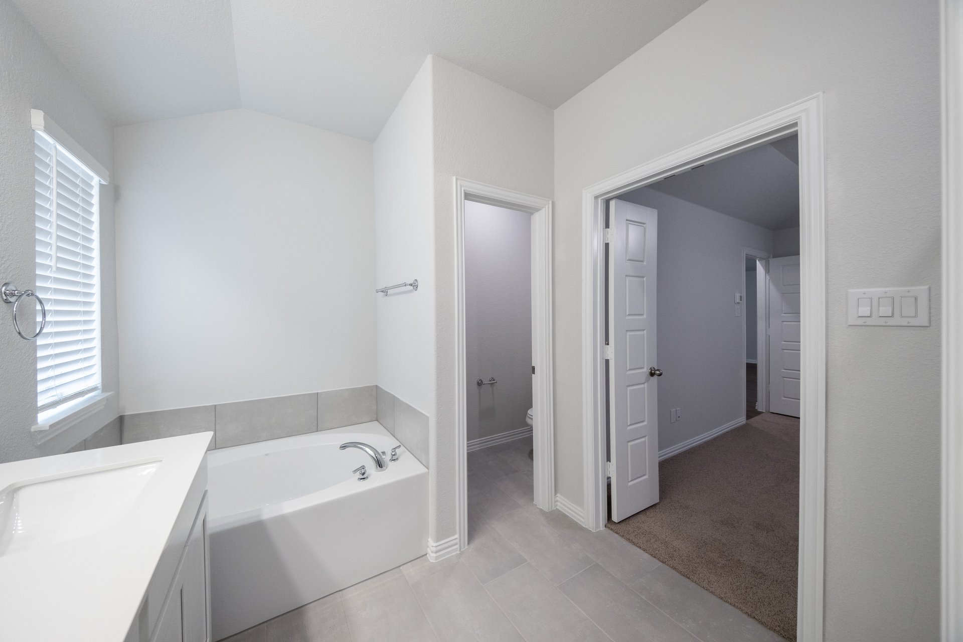 primary bathroom with walk-in shower and white cabinets