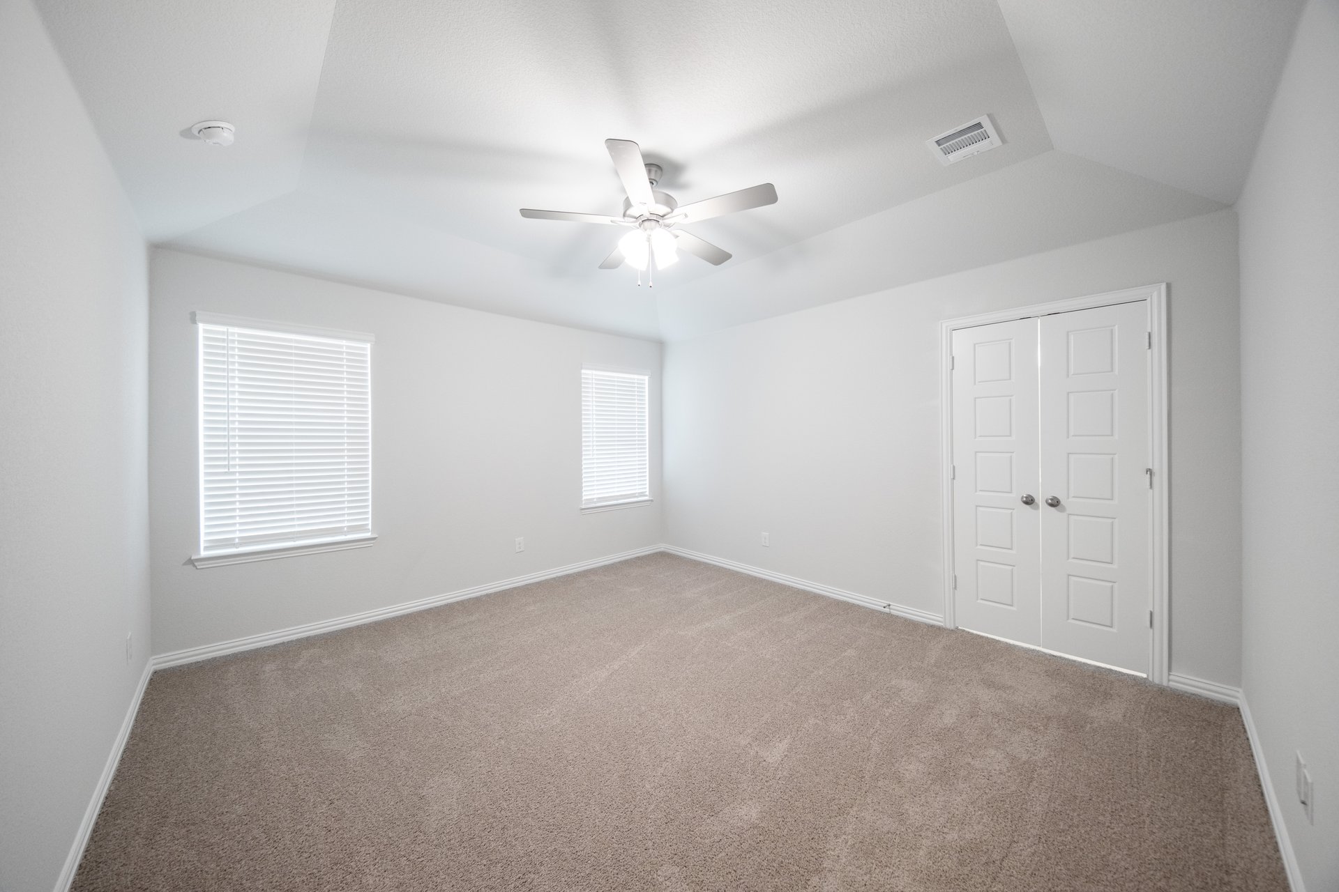 primary bedroom with carpet and windows
