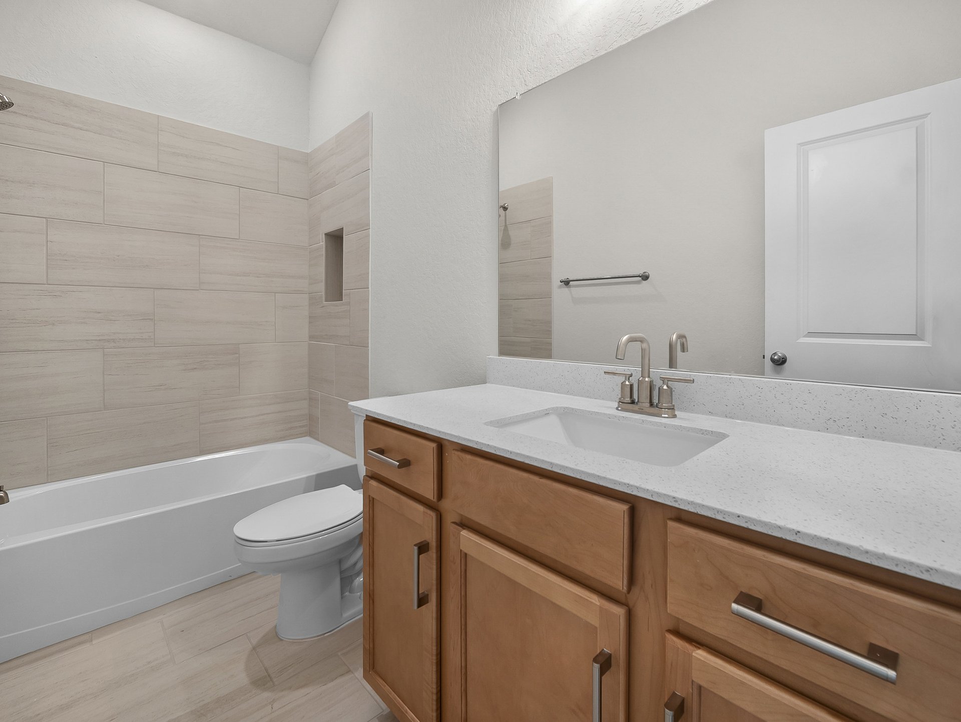bathroom with brown cabinets & tub with shower combo