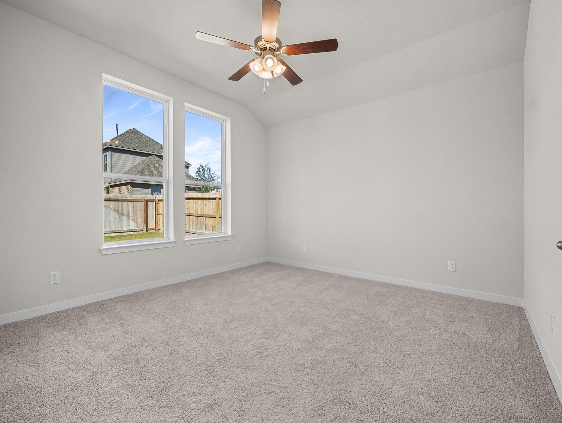bedroom with carpet, windows & a ceiling fan