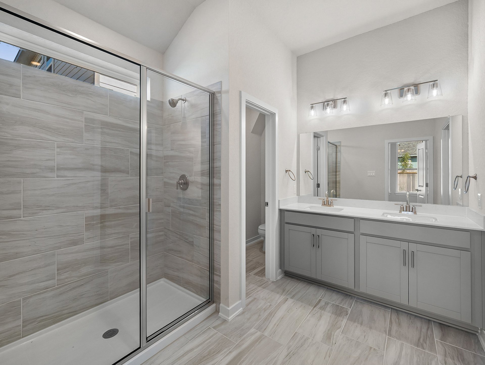 bathroom with dual sinks & a walk-in shower