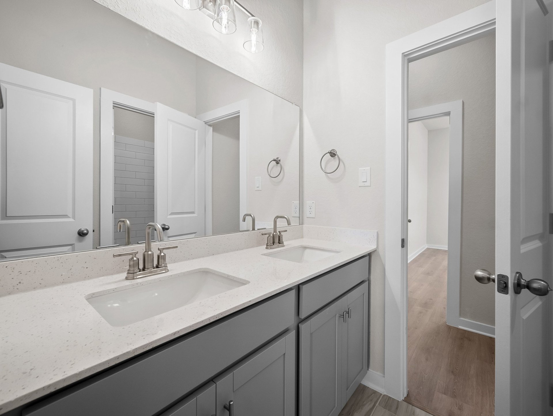 bathroom with dual sinks, quartz countertops & white cabinets