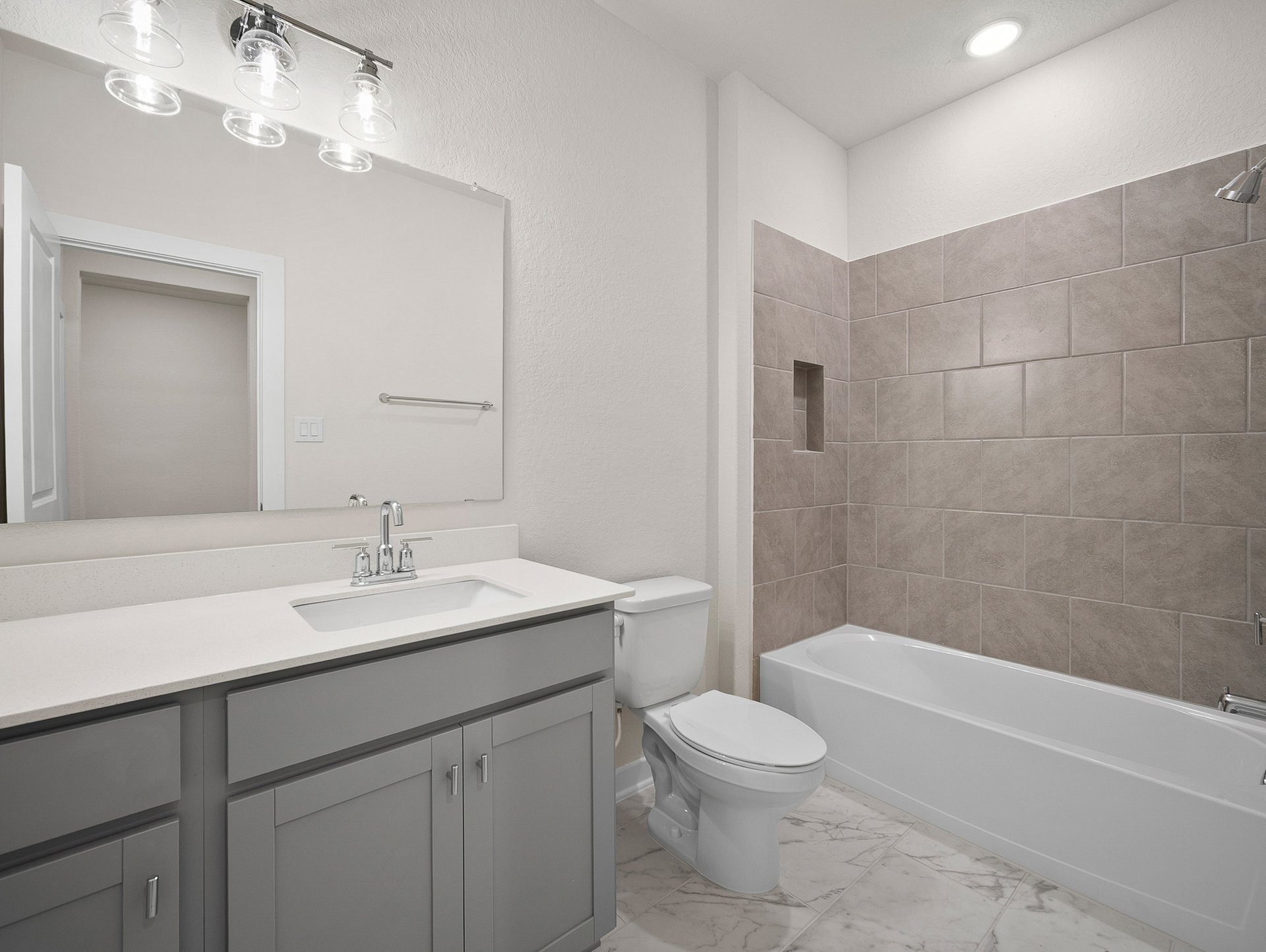 bathroom with quartz countertops & a bathtub