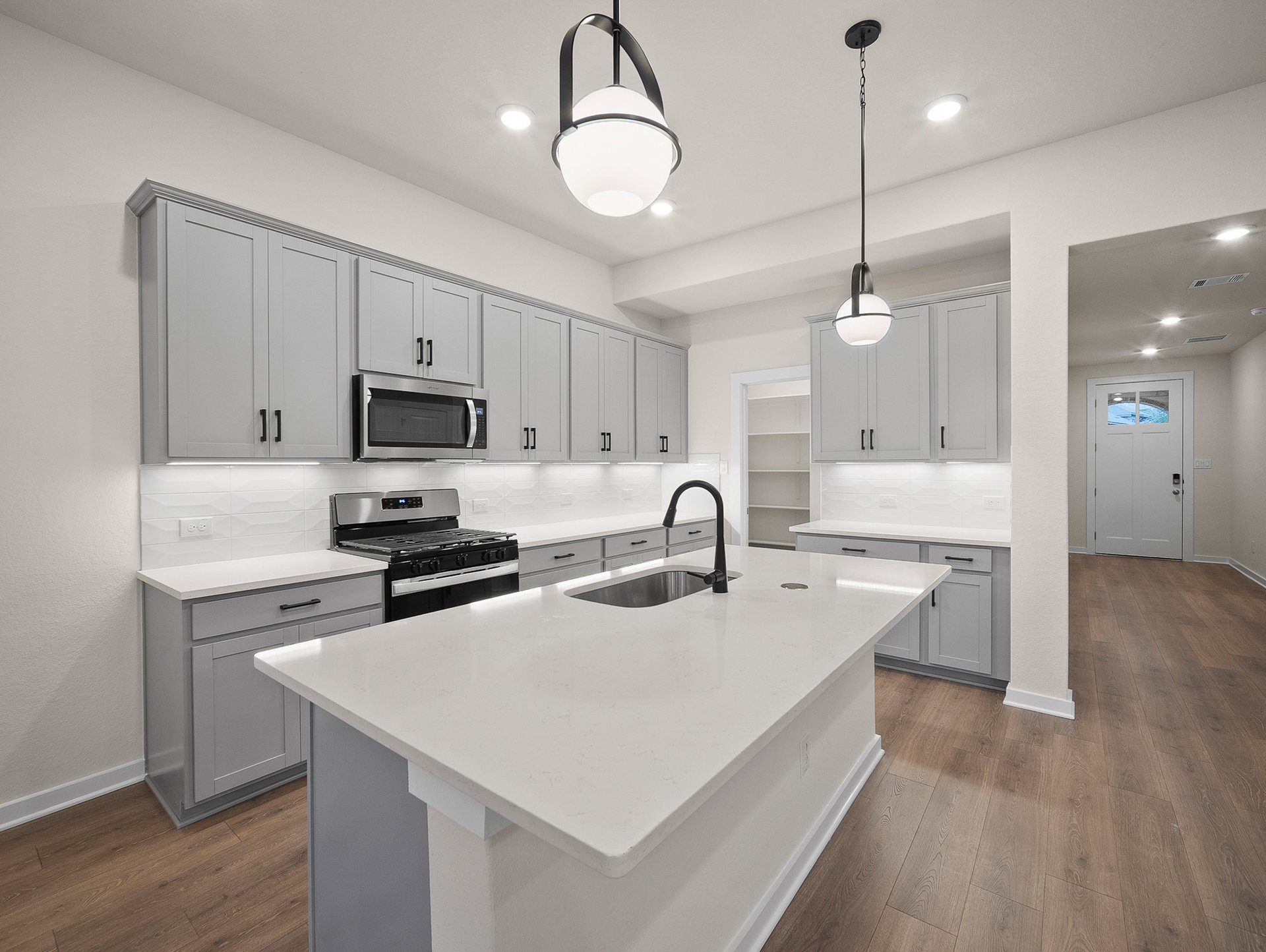 kitchen with quartz countertops, pendant lighting & gray cabinets