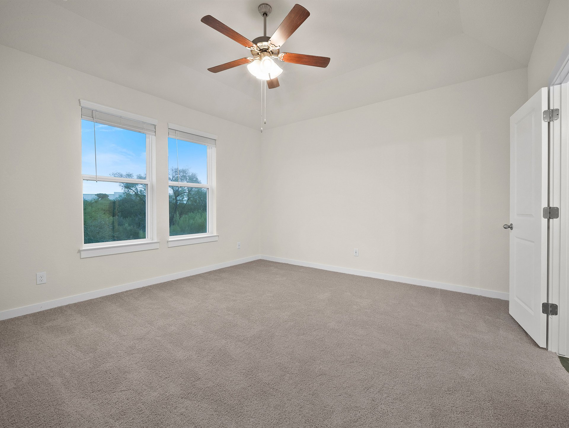 bedroom with carpet, windows & a ceiling fan