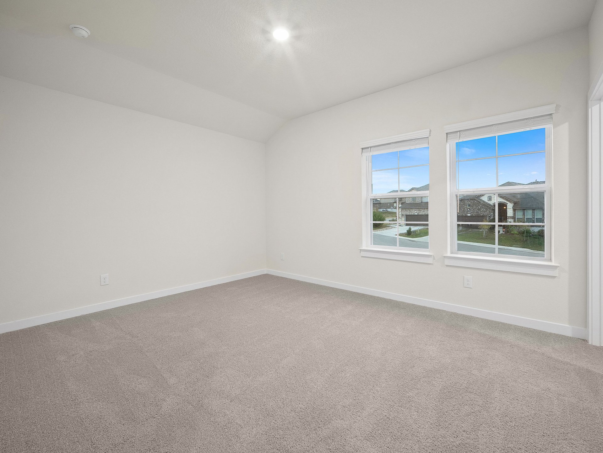 bedroom with carpet, windows & a sloped ceiling