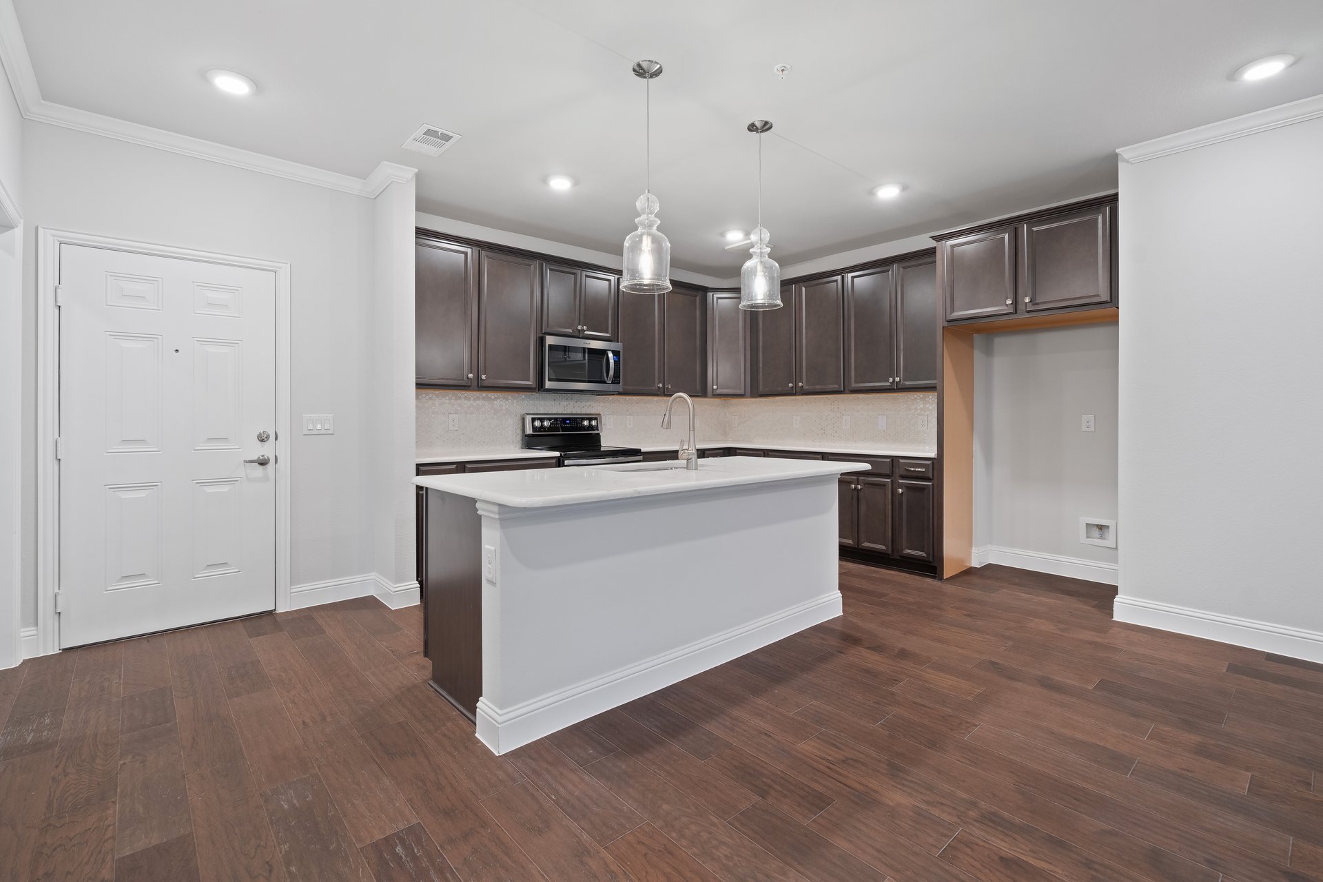open kitchen with brown cabinets and hardwood flooring