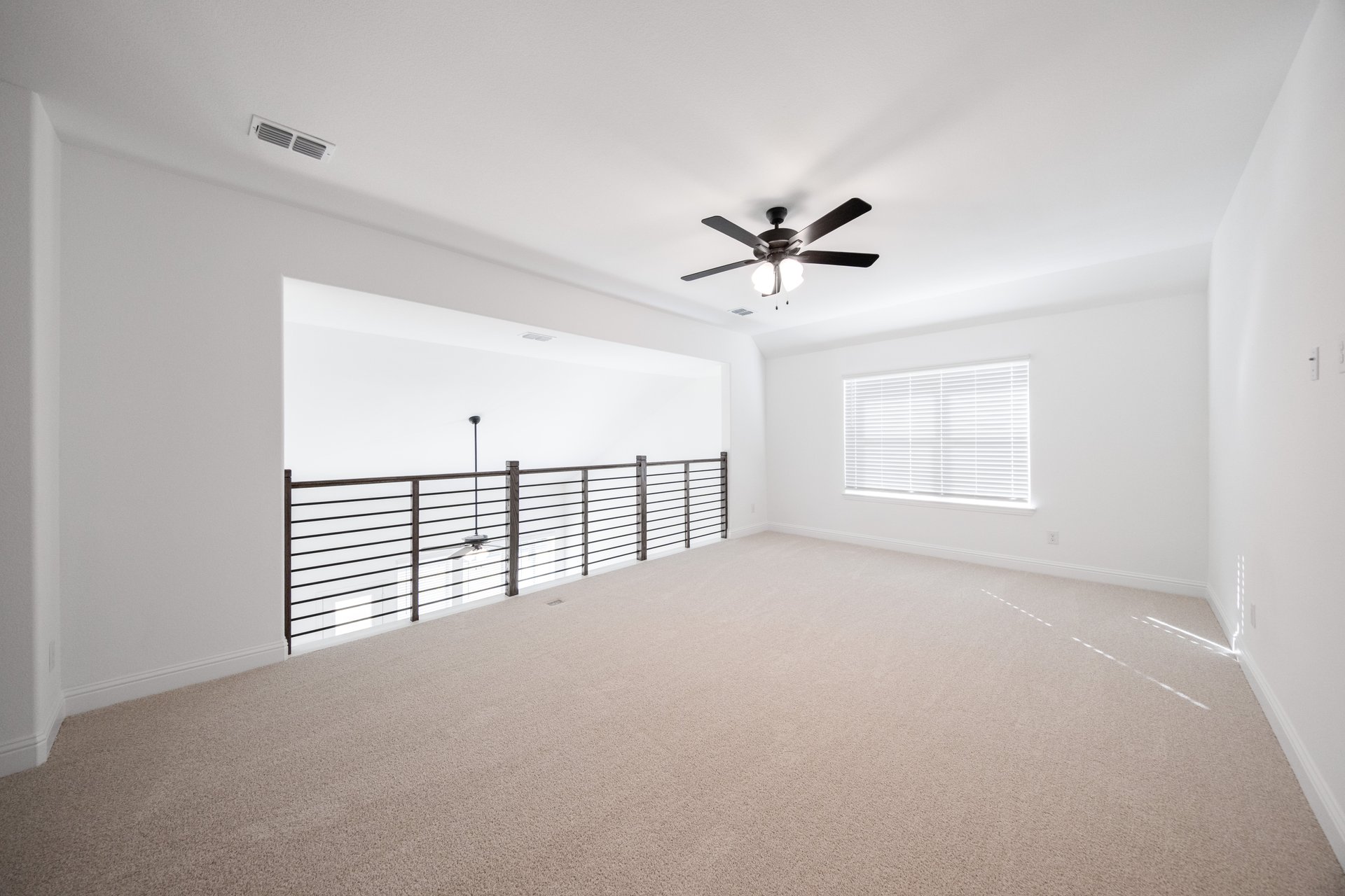 open loft with carpet, window, and ceiling fan