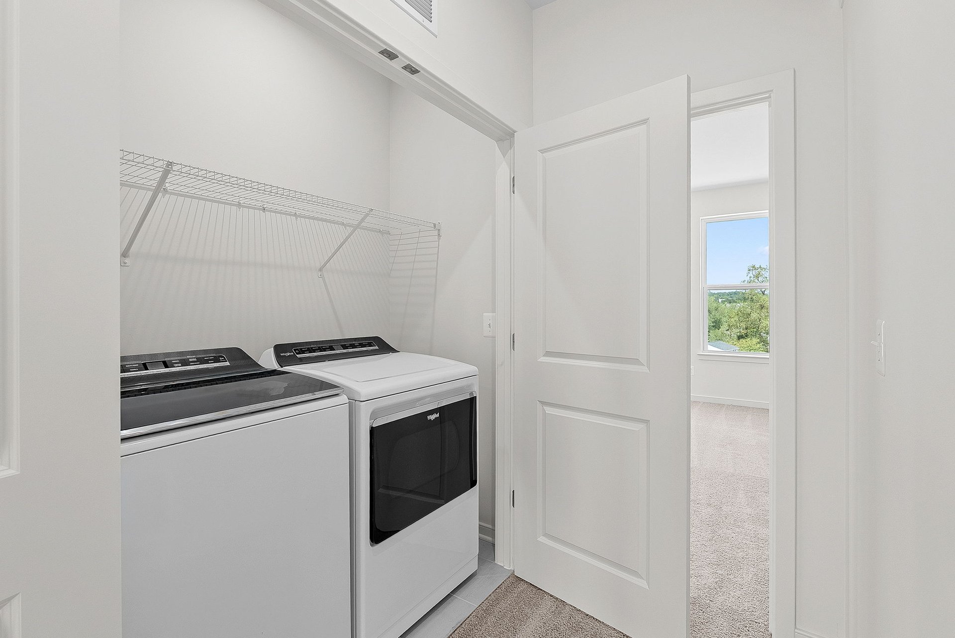 laundry room with washer and dryer and a wire shelf