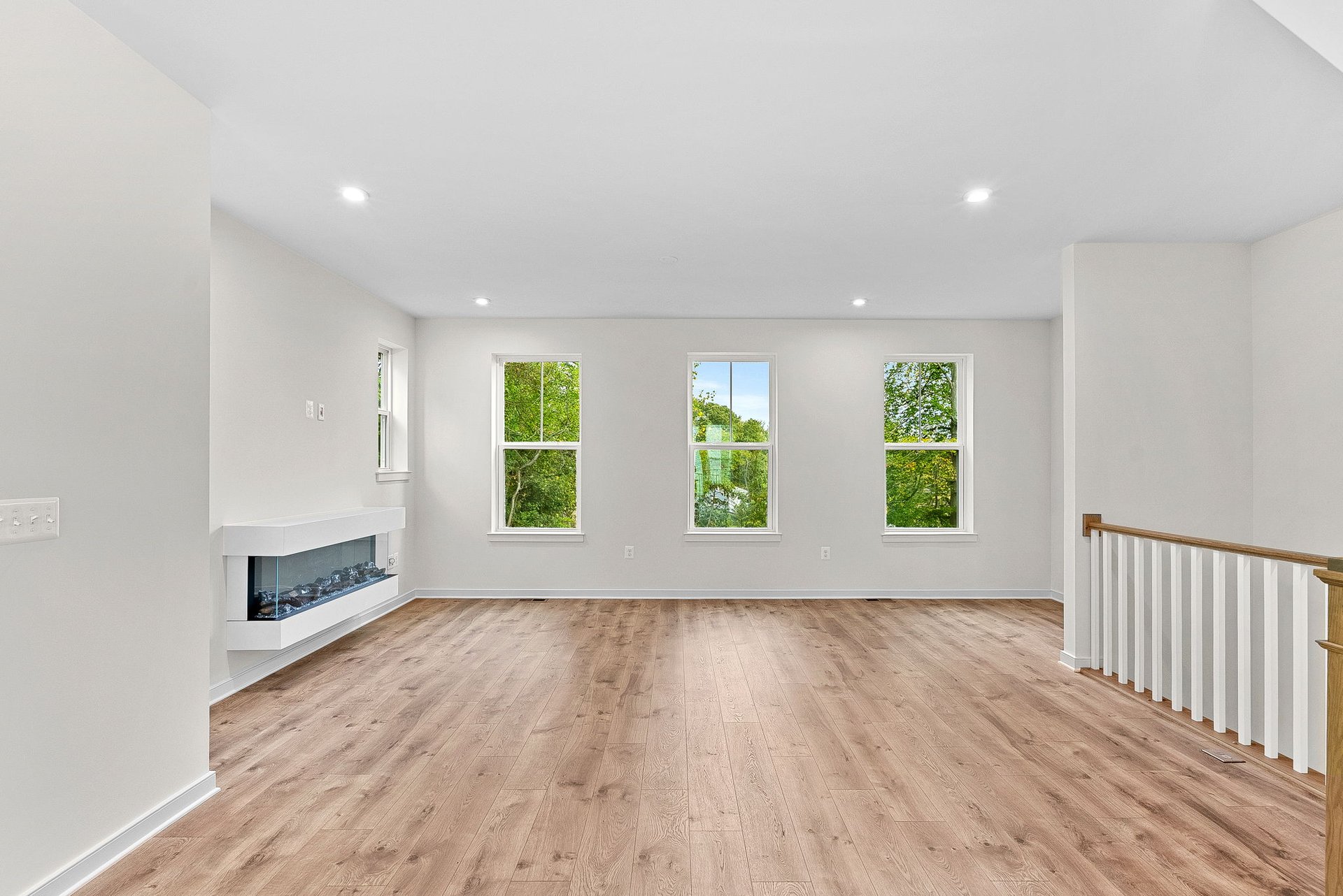 great room with a fireplace and multiple windows