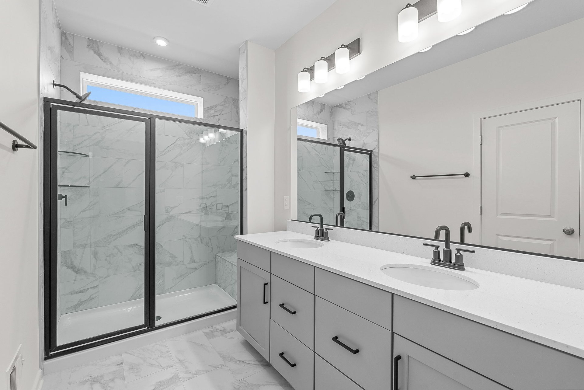 primary bathroom with two sinks and an oversized shower