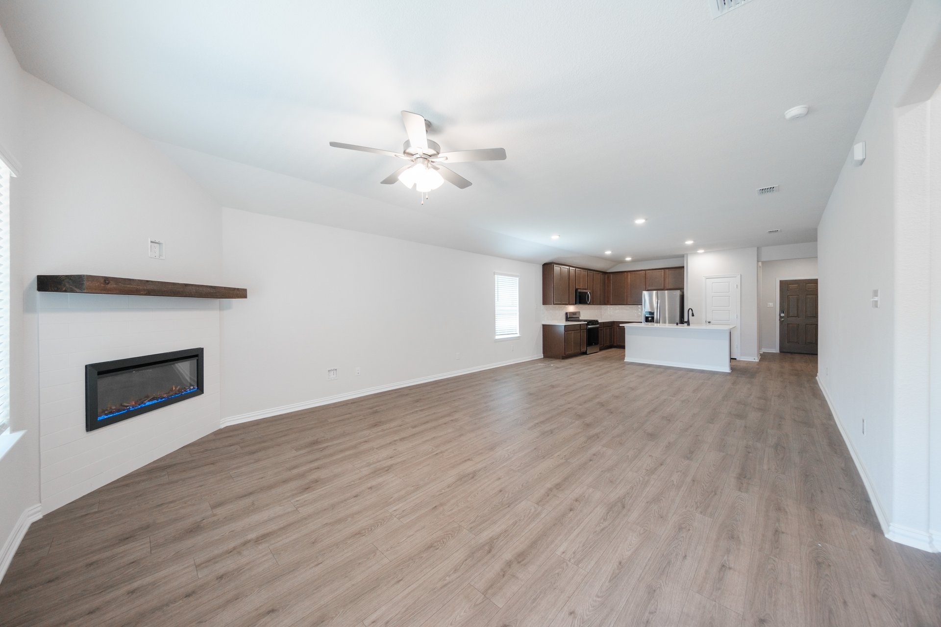 open great room with wood floors and ceiling fan