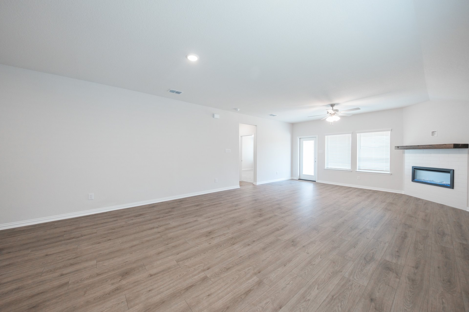 open great room with wood floors and ceiling fan