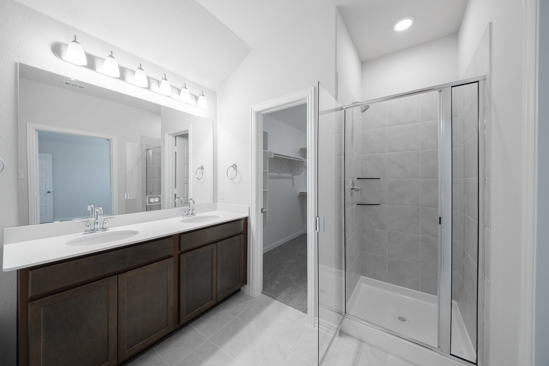 primary bathroom with walk-in shower and tile floors